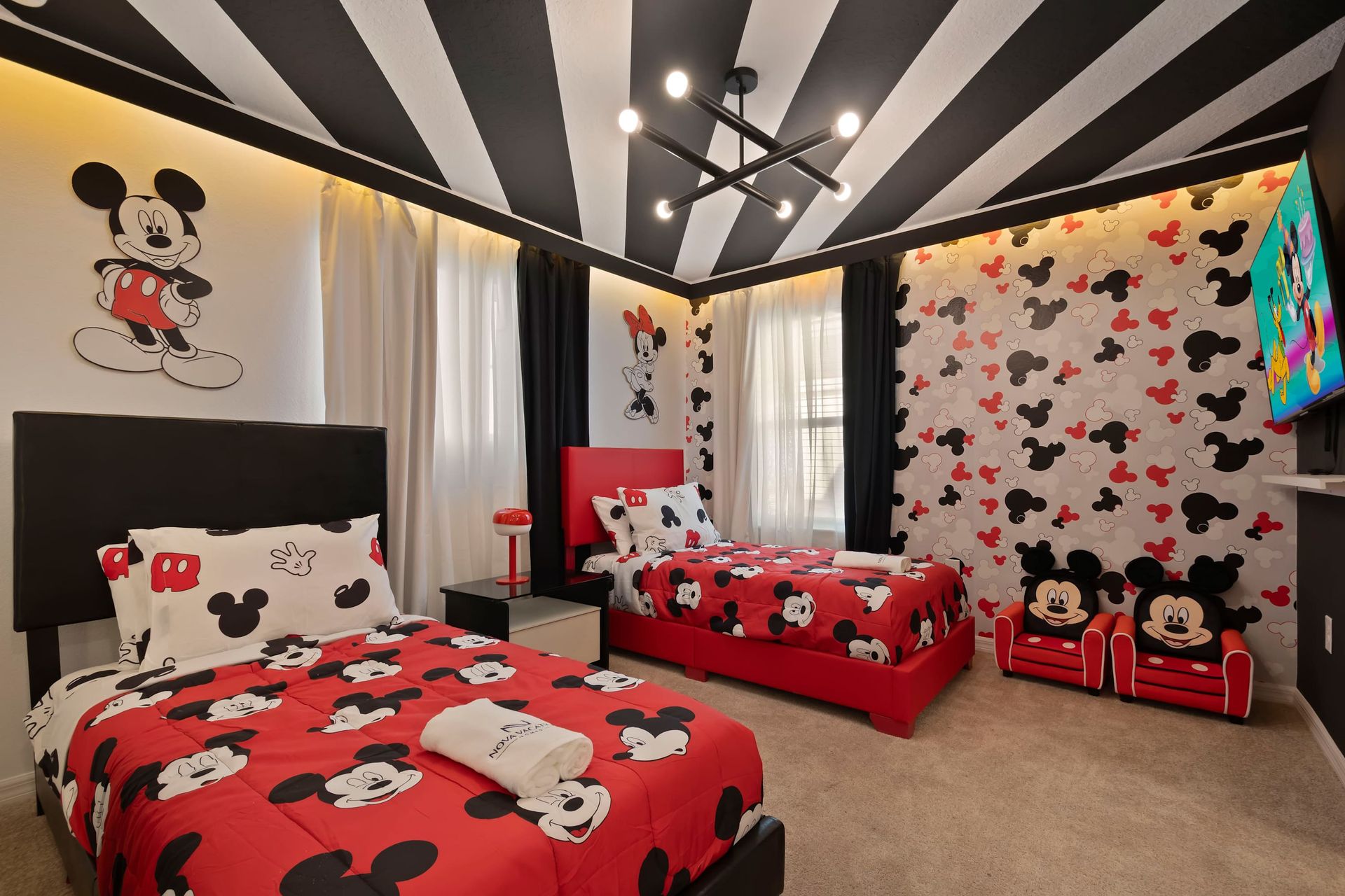 Whimsical Mickey Mouse room with bold decor, twin beds, and Disney wall art.

