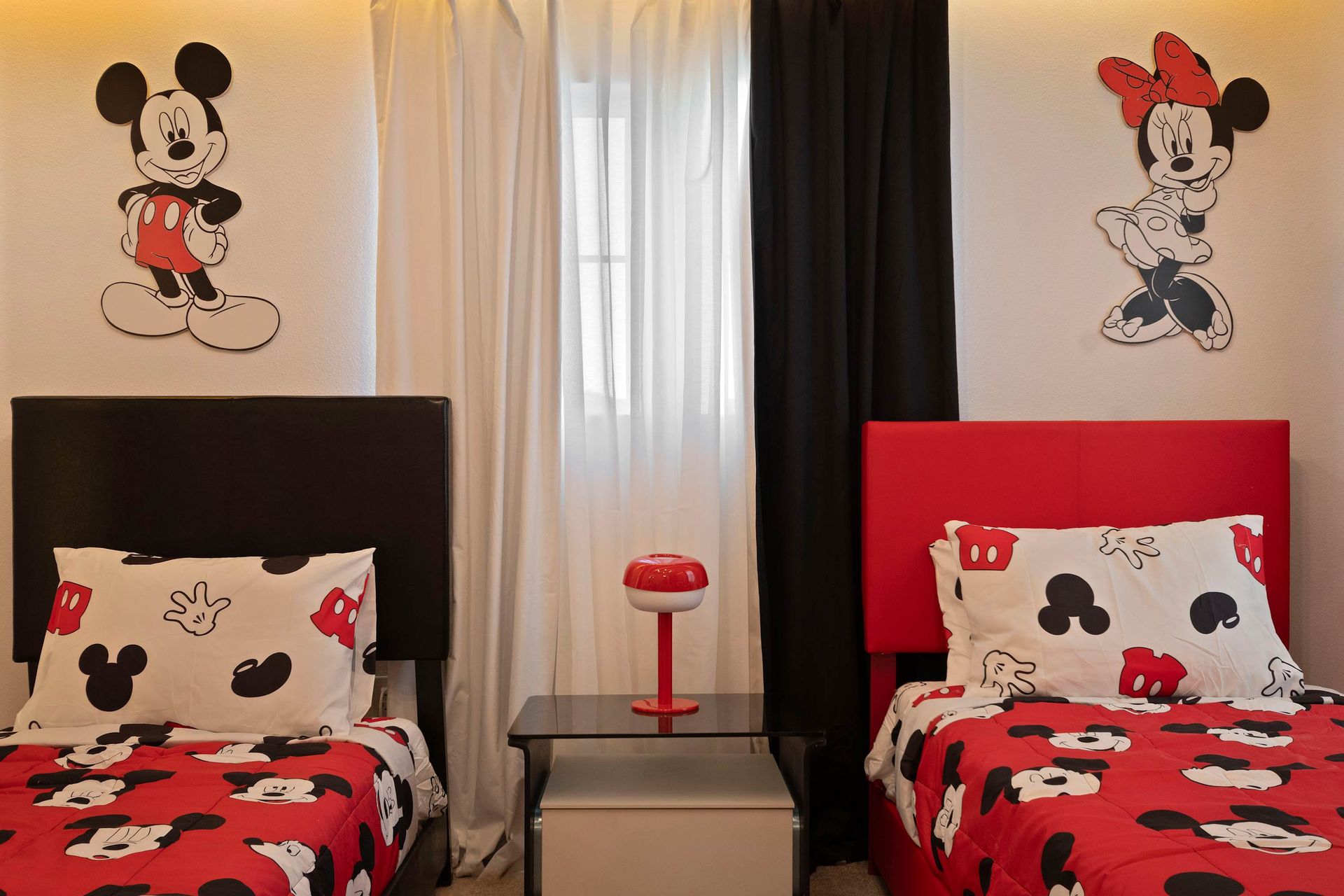 Charming Mickey and Minnie room with twin beds, themed decor, and cozy vibes.
