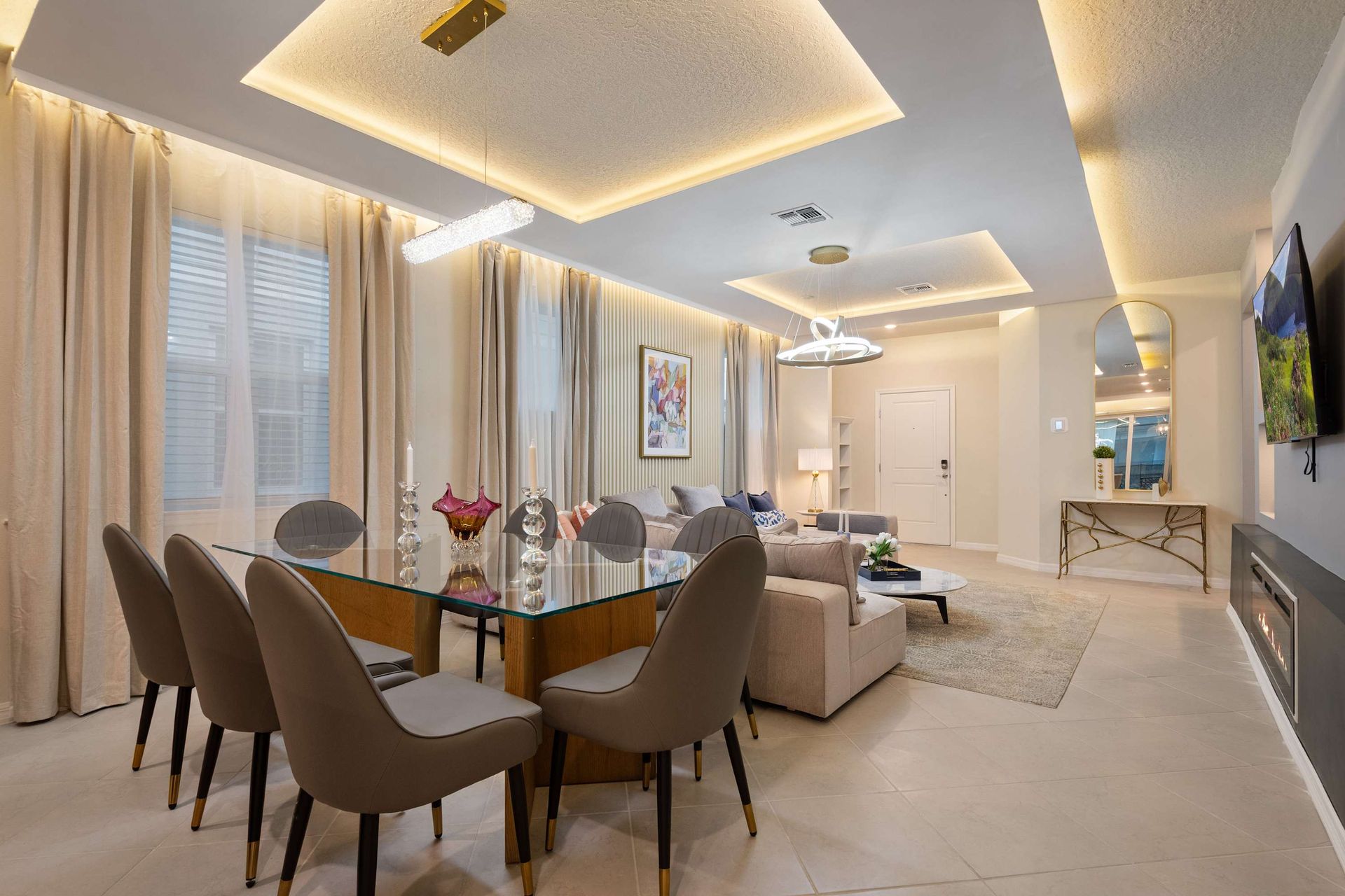 Elegant dining and living space with modern lighting, sleek decor, and open flow.
