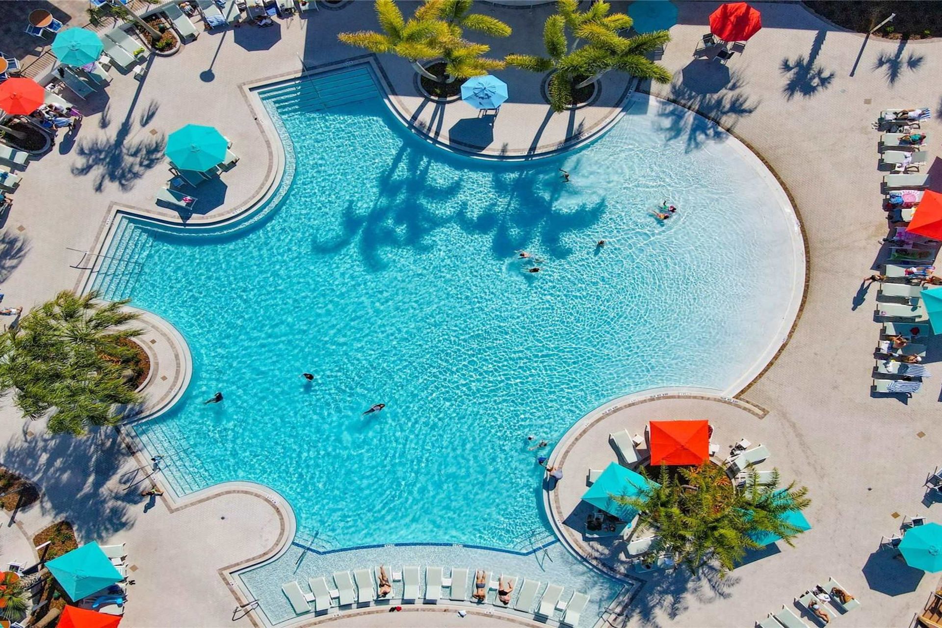 Lounge in luxury beside a stunning resort-style pool with vibrant umbrellas.