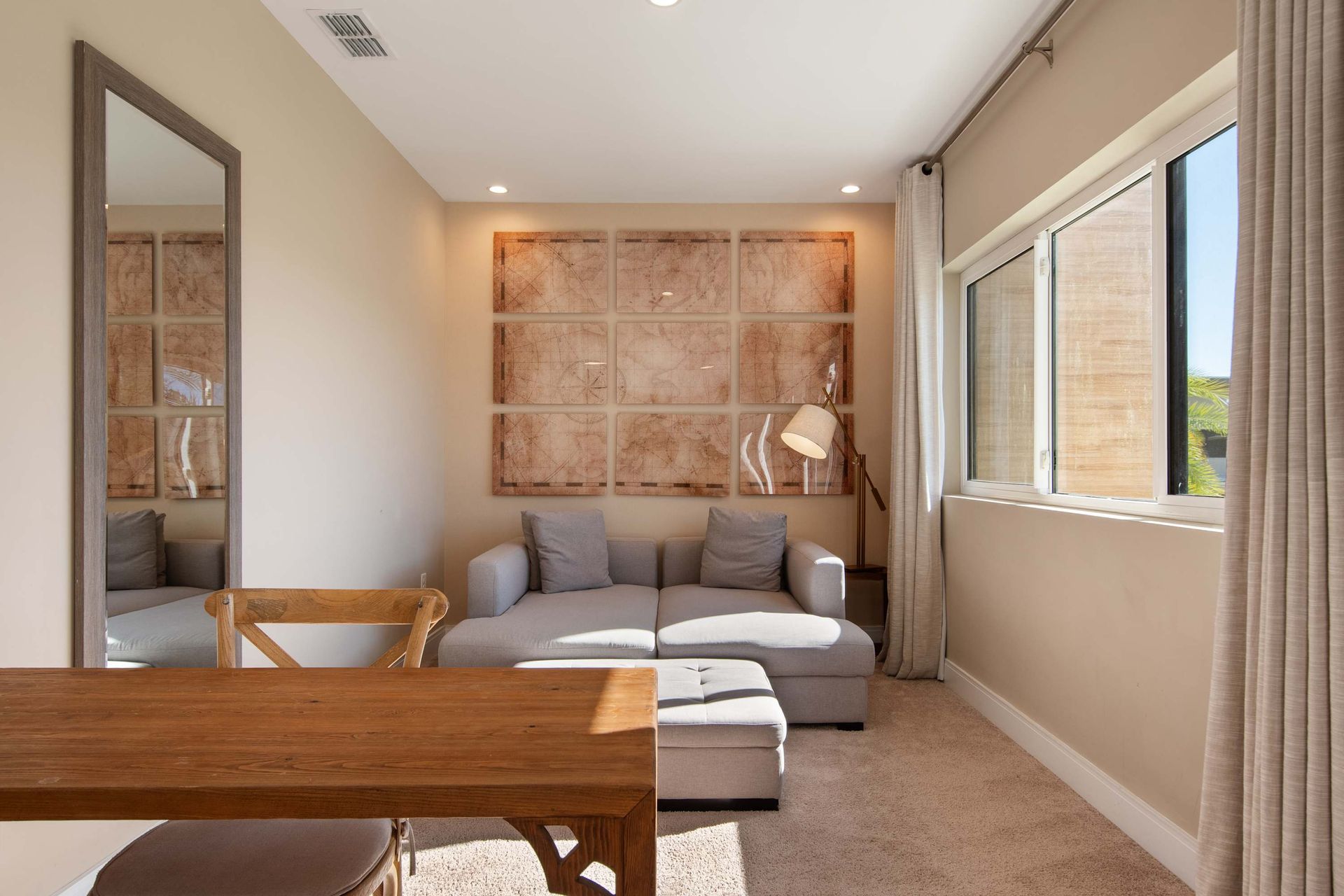 Spacious bedroom with king bed, cozy lounge, work desk, and warm relaxing decor.