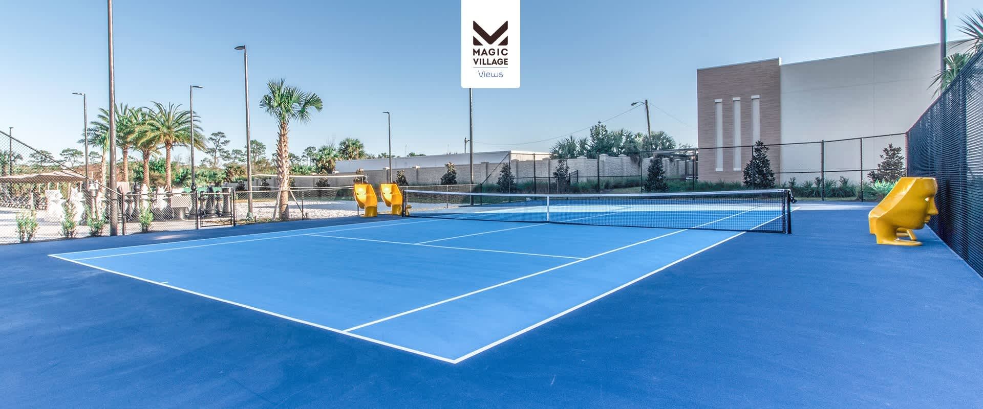 Spacious blue tennis court surrounded by palm trees, perfect for an active getaway.
