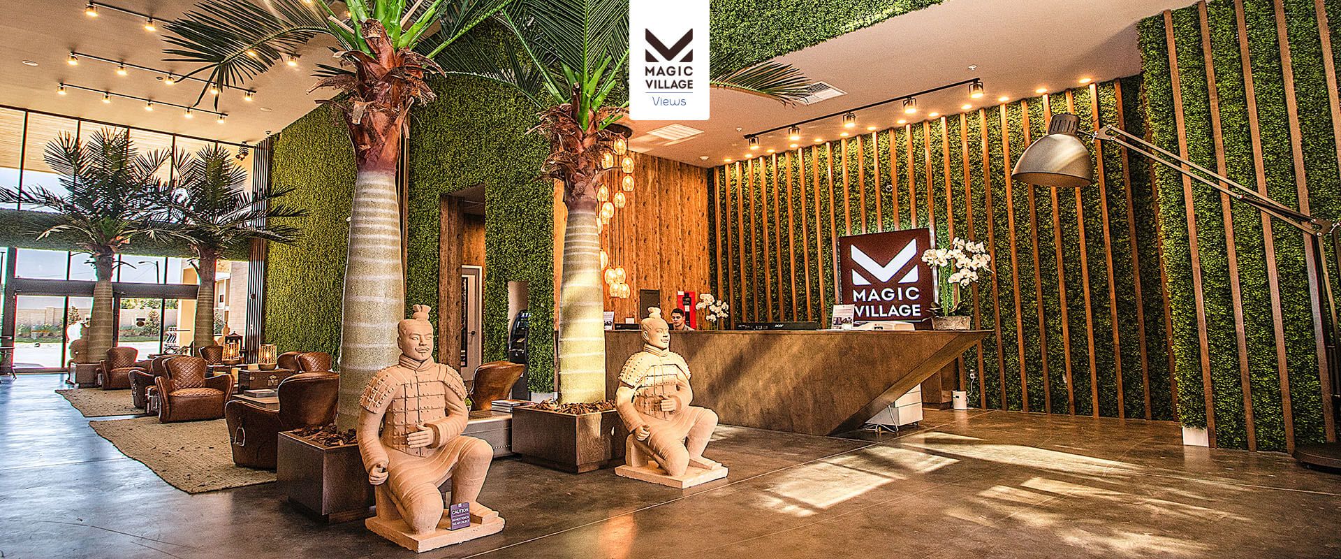 Lush resort lobby with tropical decor, bold statues, and warm upscale ambiance
