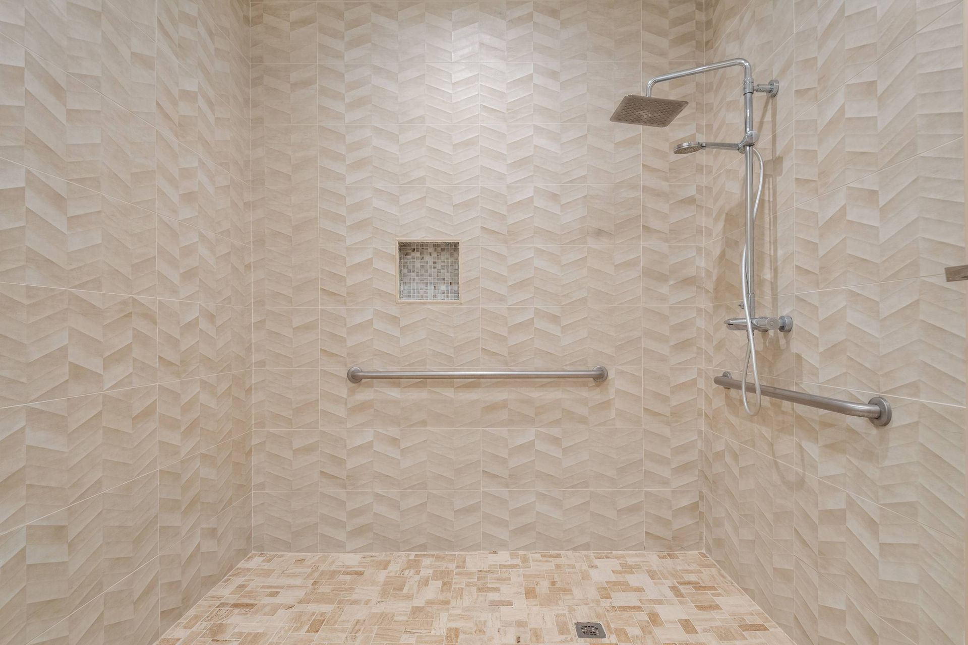 Spacious walk-in shower with rainfall head, handheld spray, and safety grab bars.
