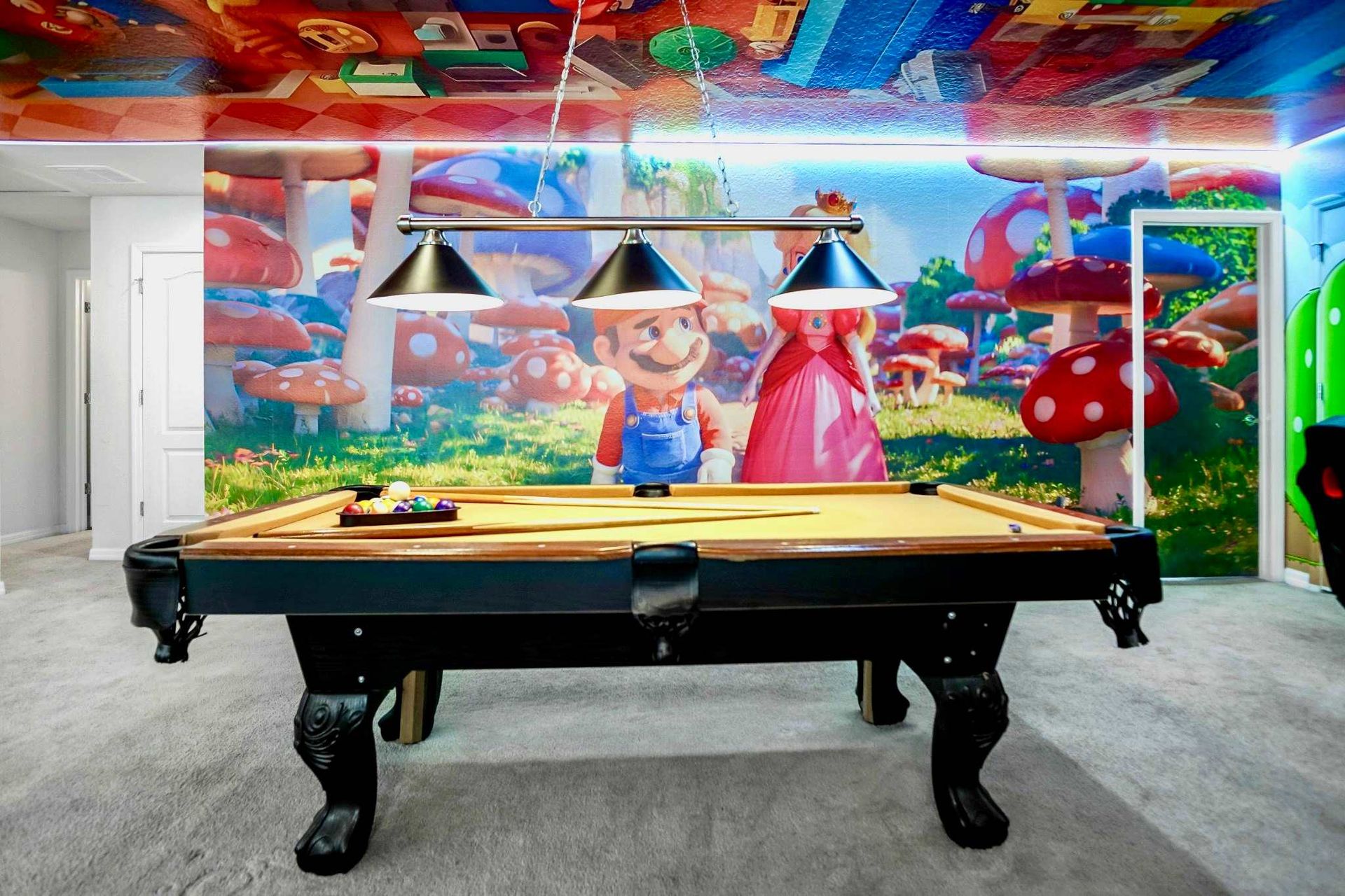 Themed game room with pool table, colorful murals, and playful atmosphere.
