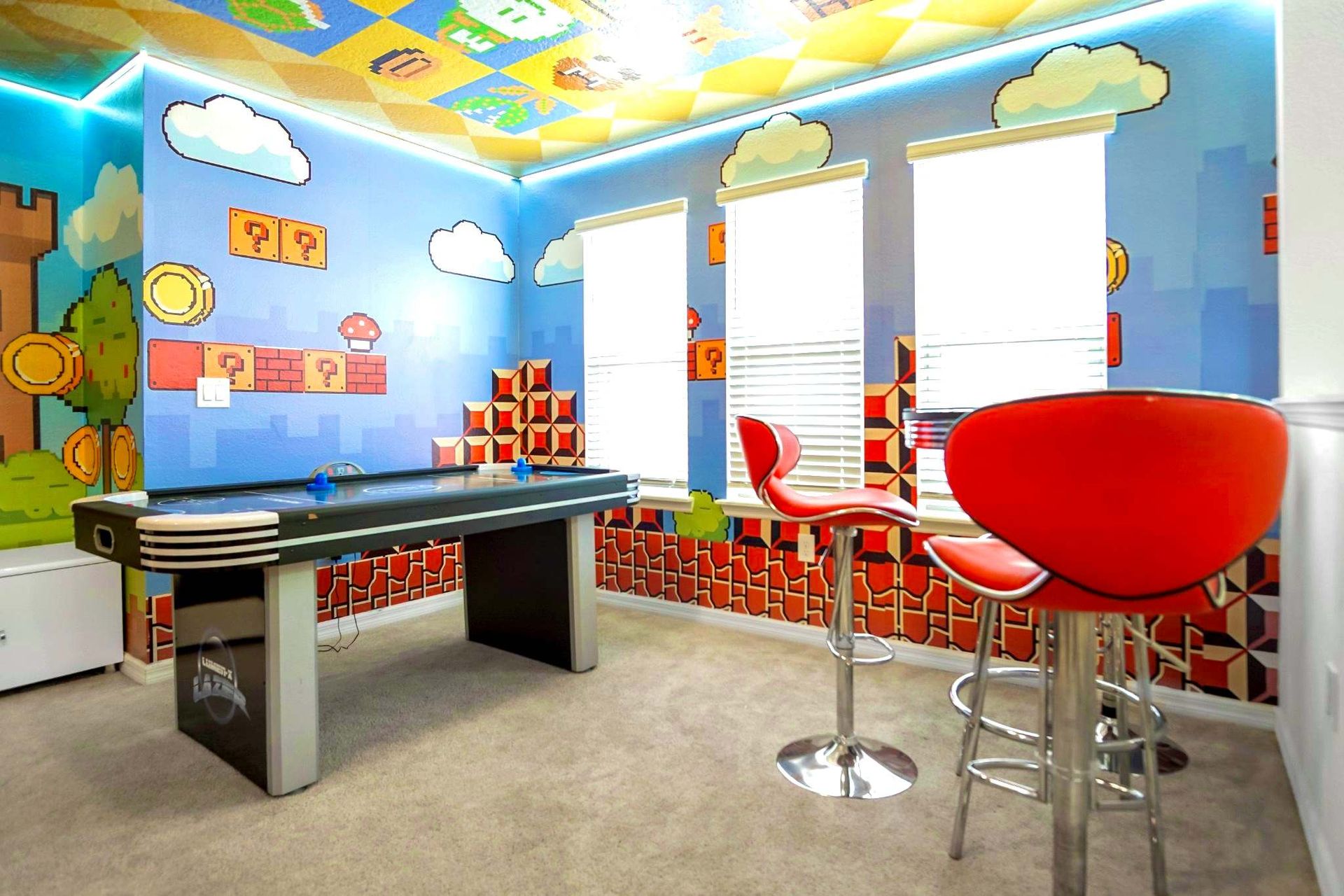 Fun-filled game room with air hockey, bar seating, and bold themed walls.