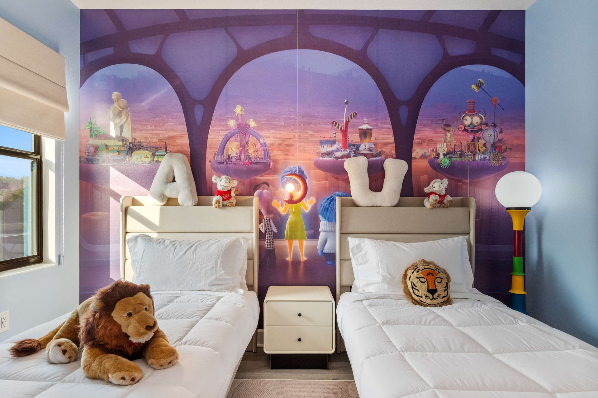 Charming kids' room with twin beds, playful décor, and vibrant animated wall mural
