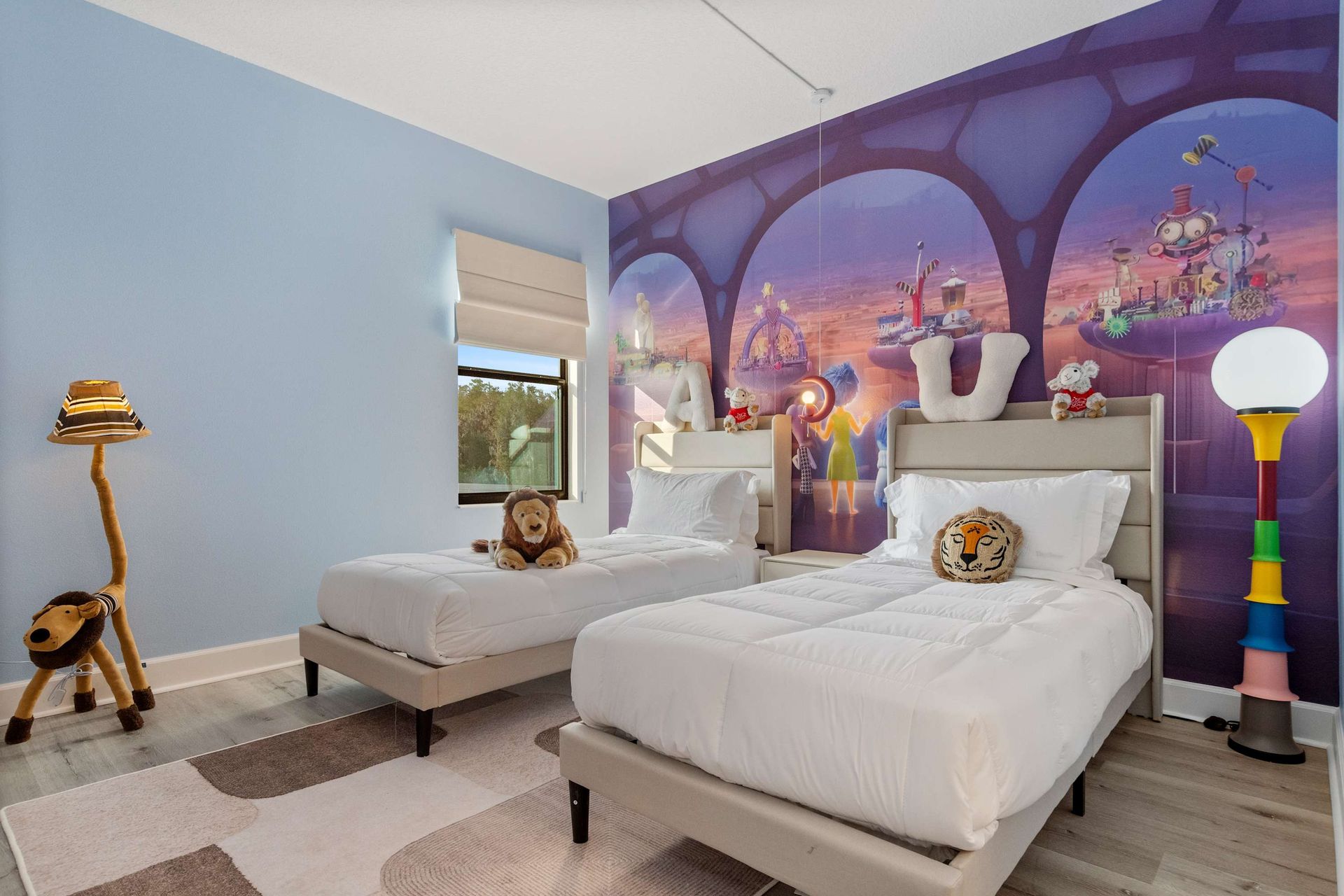 Charming kids' room with twin beds, playful décor, and vibrant animated wall mural
