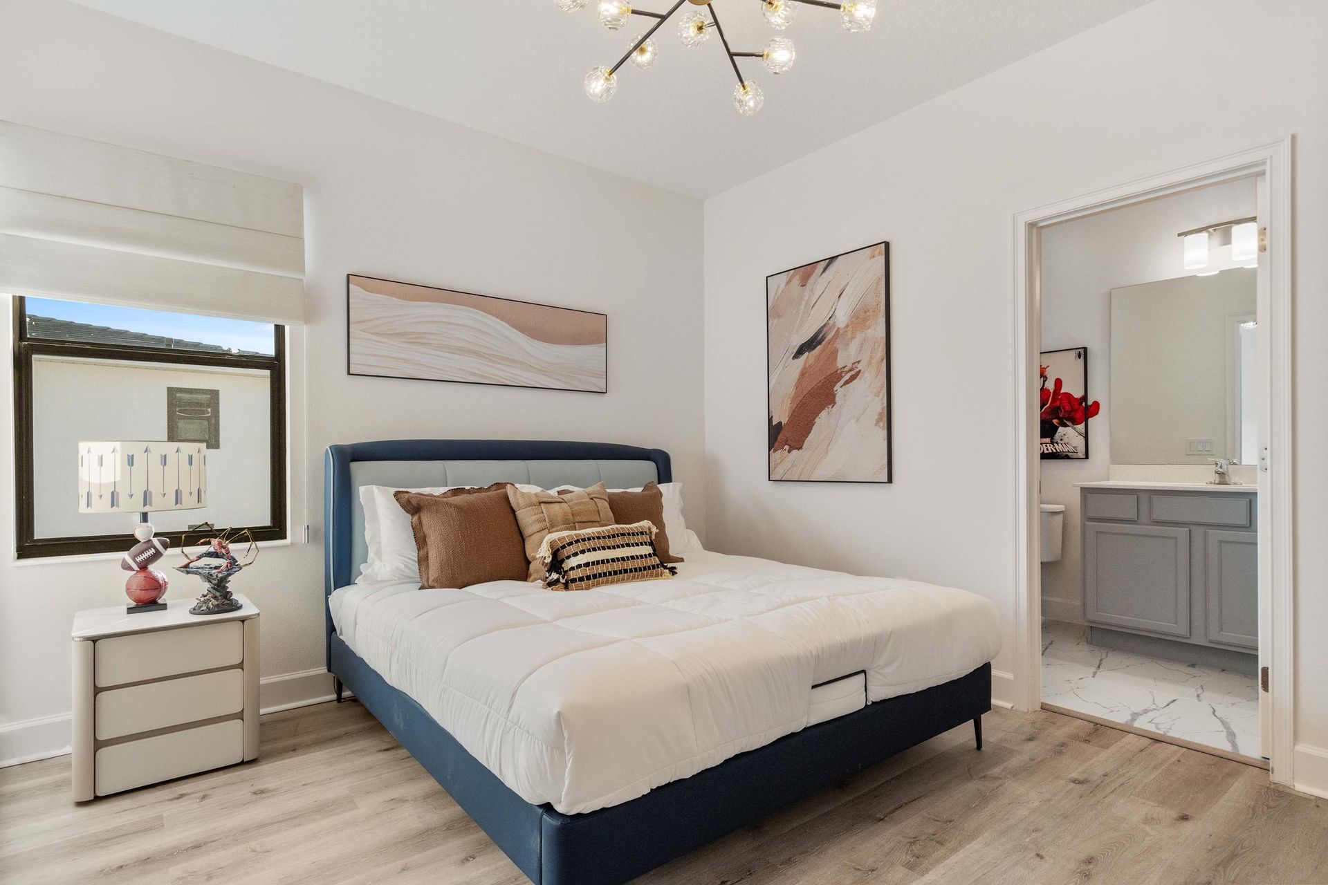 Modern bedroom with king bed, stylish lighting, and private en-suite bathroom
