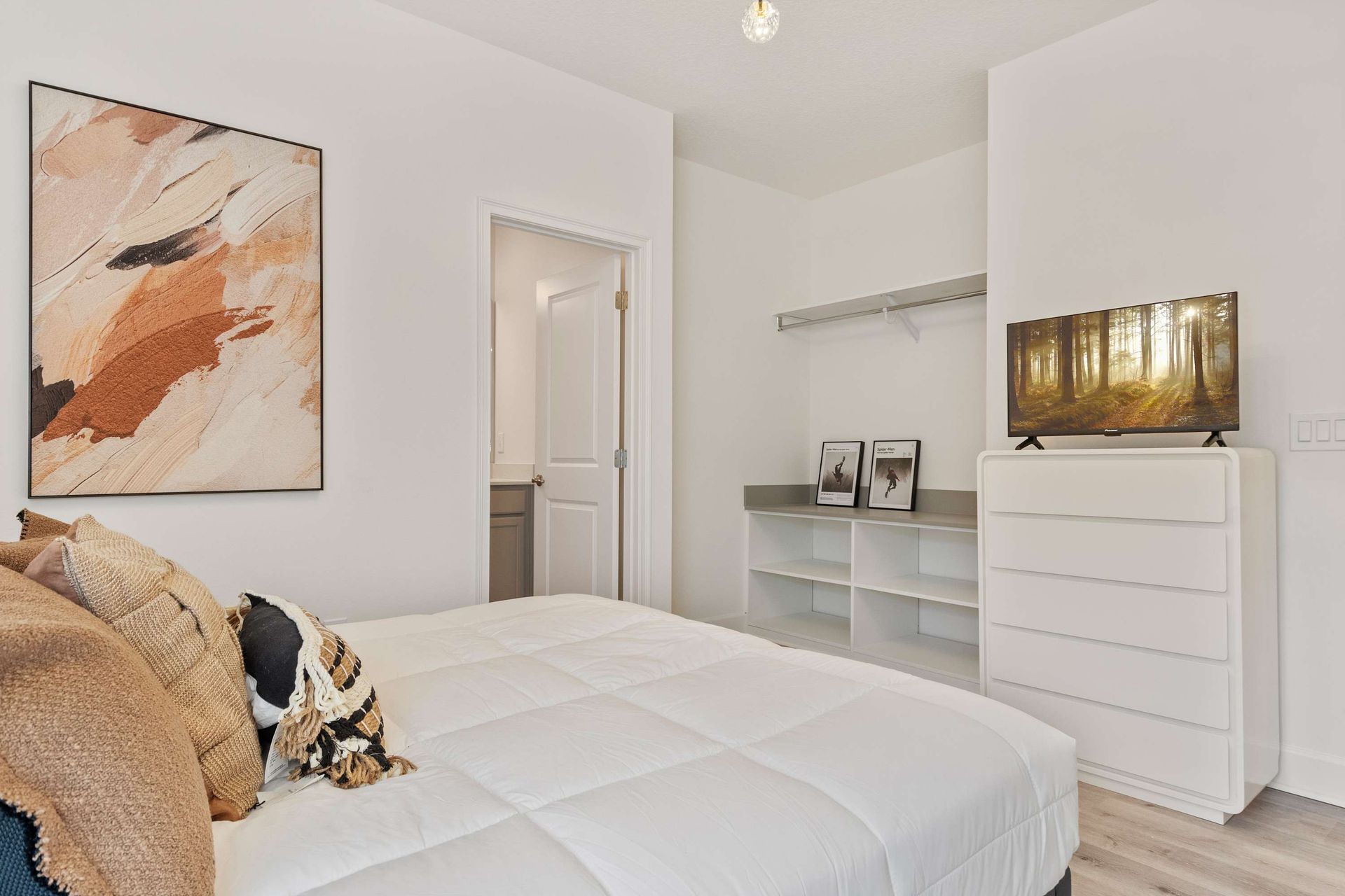 Modern bedroom with king bed, stylish lighting, and private en-suite bathroom
