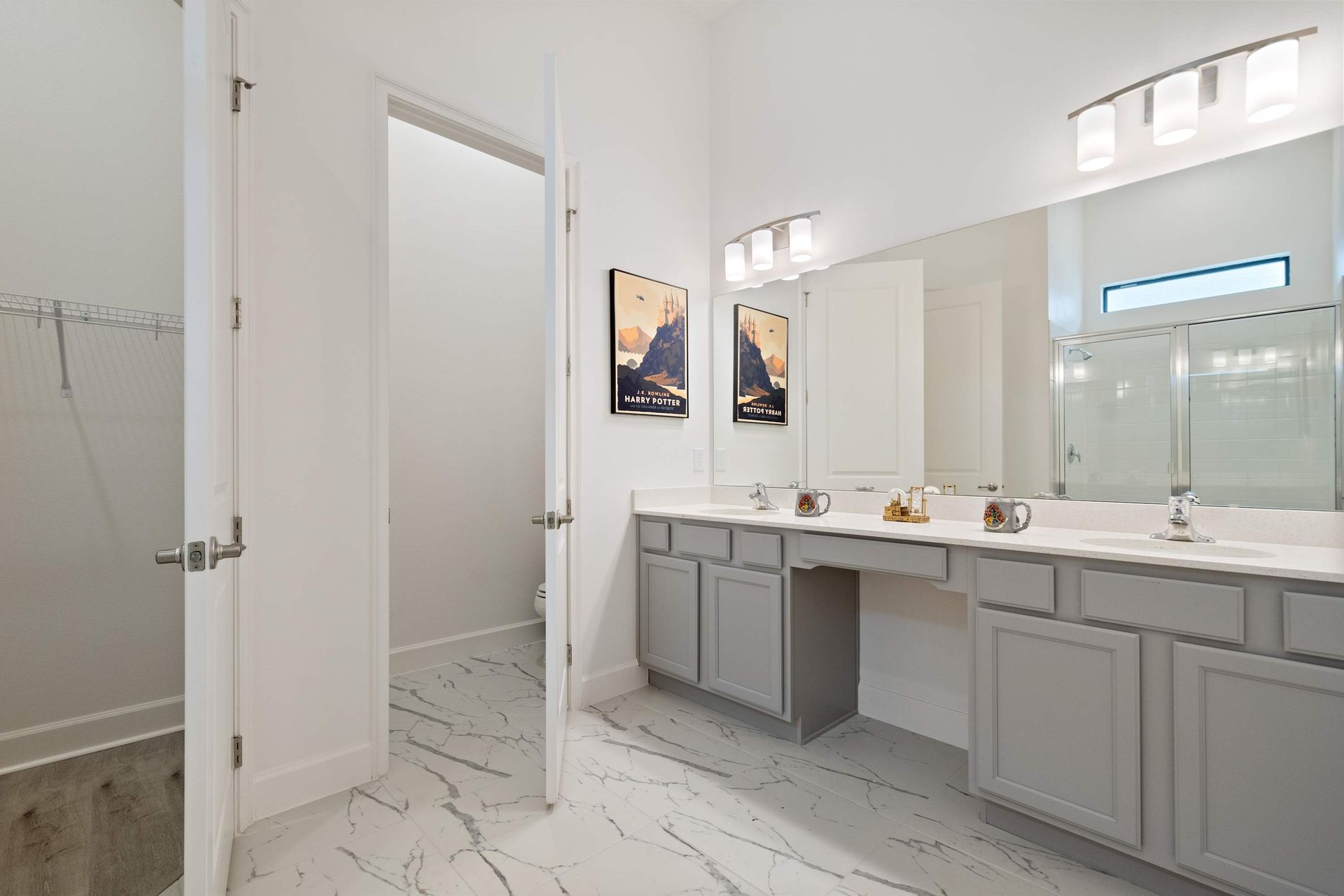 Spacious ensuite bathroom with dual sinks, walk-in closet, and sleek modern design
