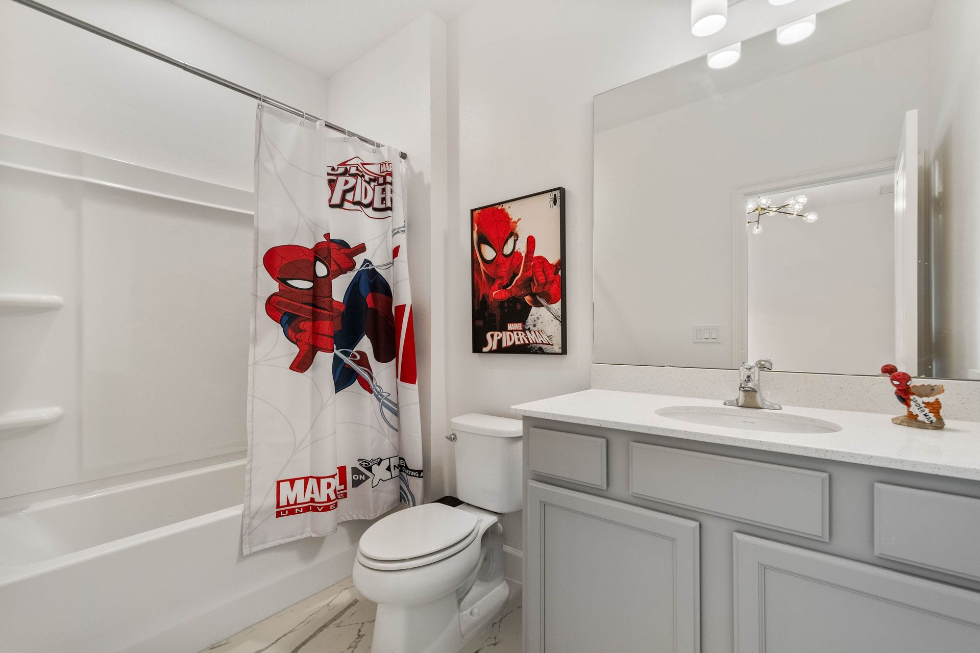Superhero-themed bathroom featuring bold artwork, character shower curtain, and sleek vanity
