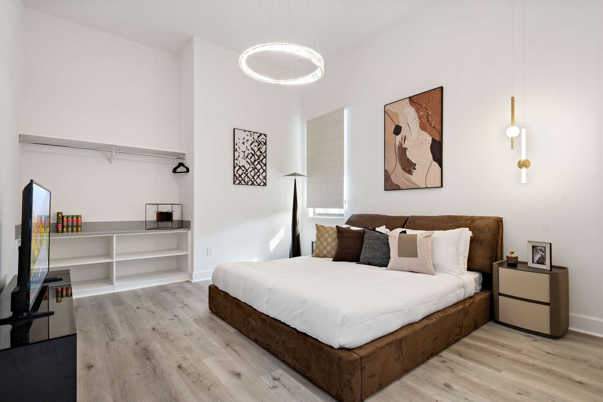 Contemporary bedroom with plush king bed, modern art, and stylish open closet
