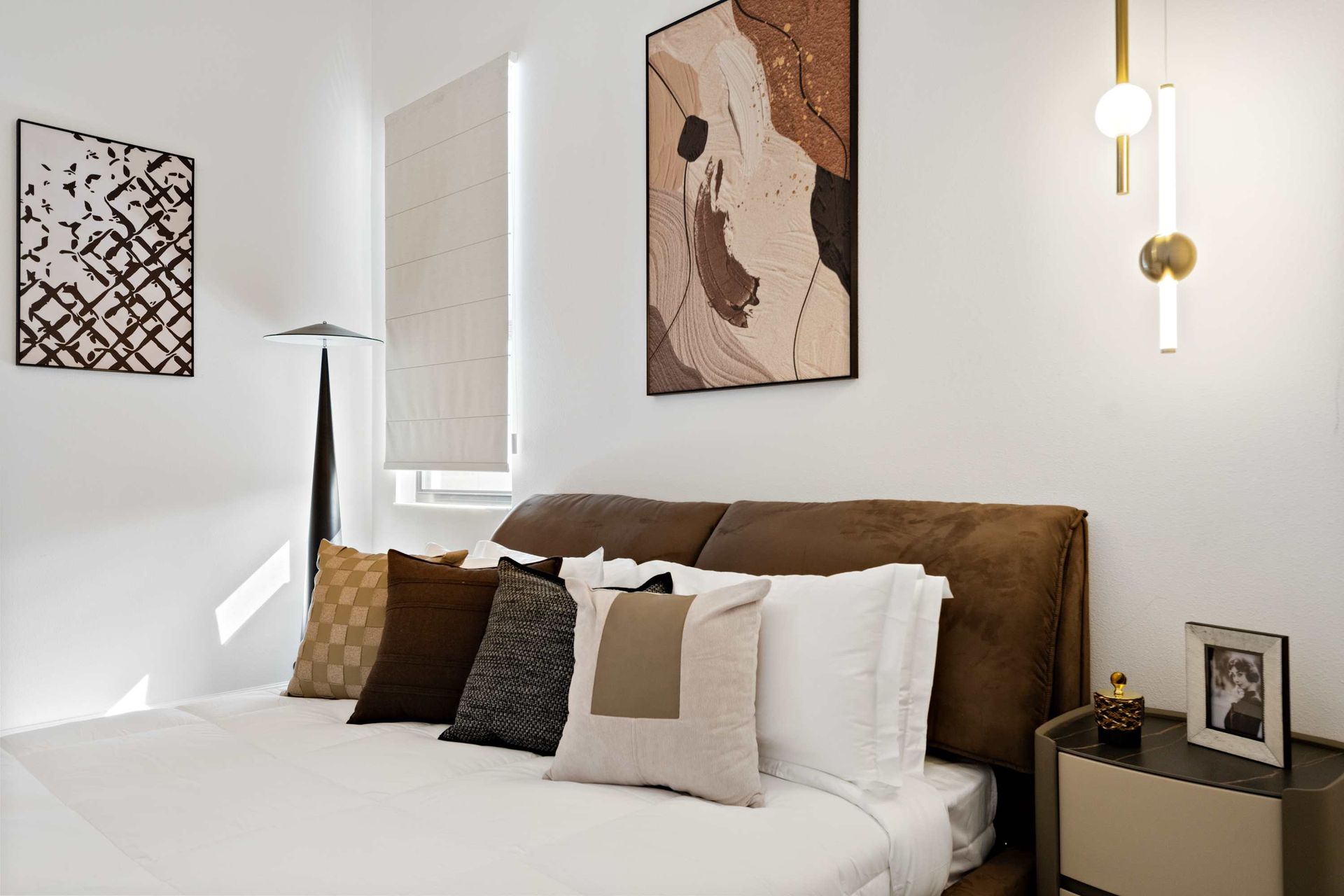 Contemporary bedroom with plush king bed, modern art, and stylish open closet
