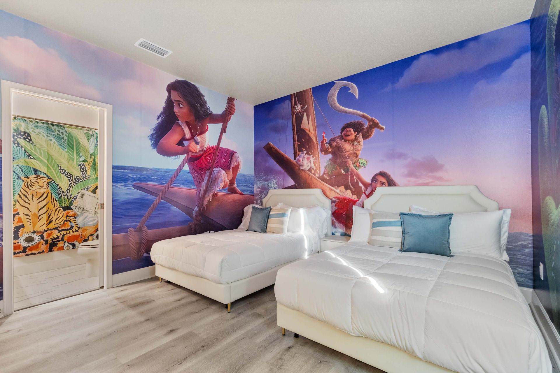 Tropical ocean-themed kids’ room with twin beds and bold adventure wall mural
