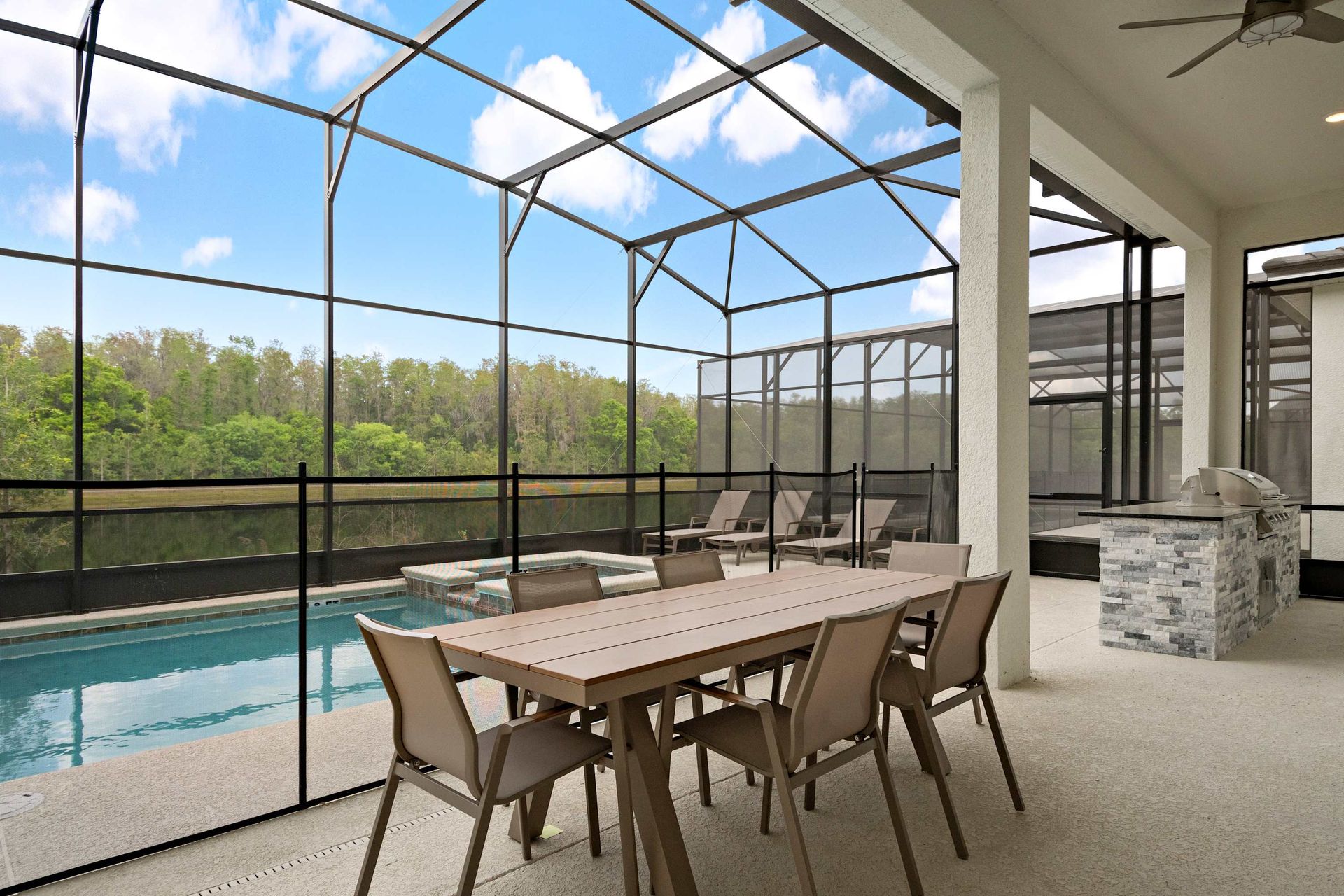 Screened-in patio with private pool, dining area, loungers, and built-in grill station
