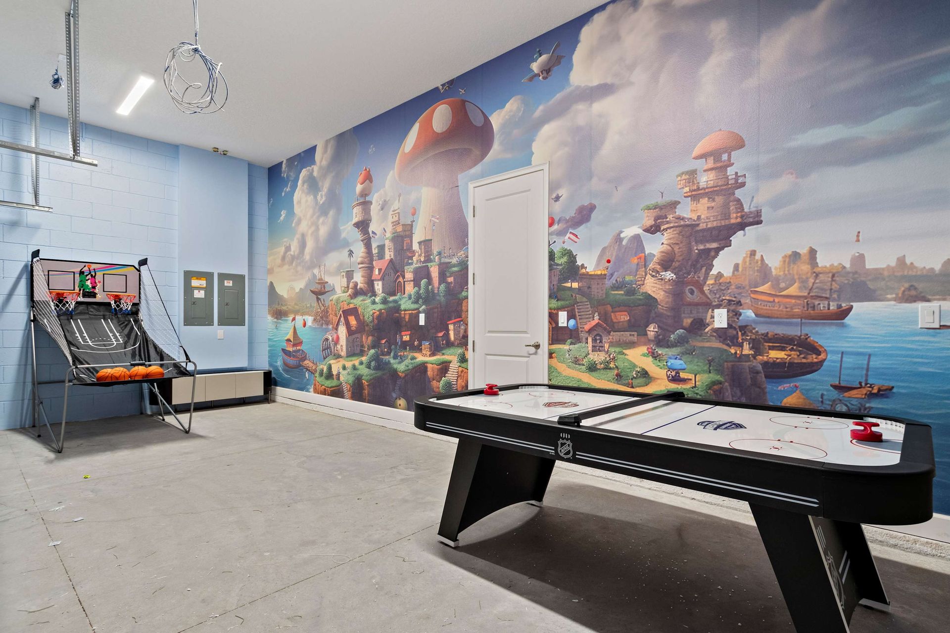 Epic game room with air hockey, basketball shootout, and vibrant adventure mural
