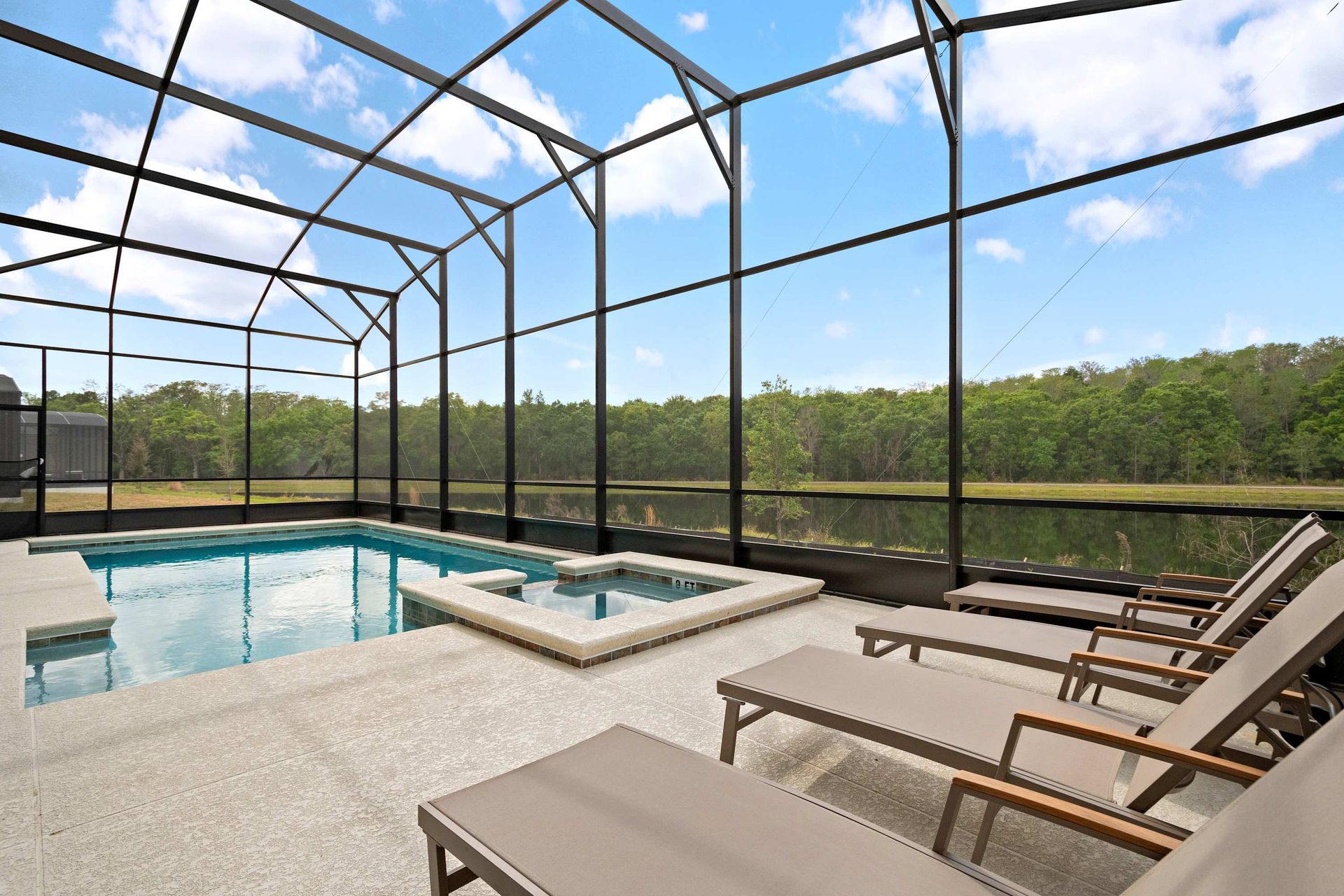 Screened-in pool and spa with serene lake views and plenty of lounge seating
