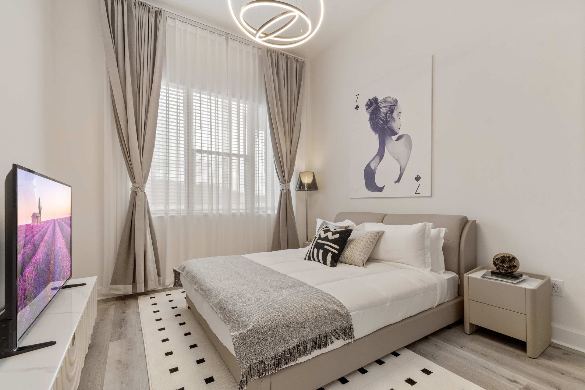 Stylish bedroom with chic décor, cozy king bed, and large TV for relaxing nights
