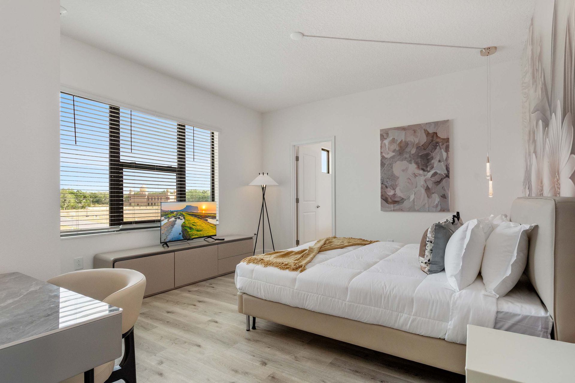 Sunlit bedroom with cozy seating nook, modern décor, and a peaceful, airy vibe
