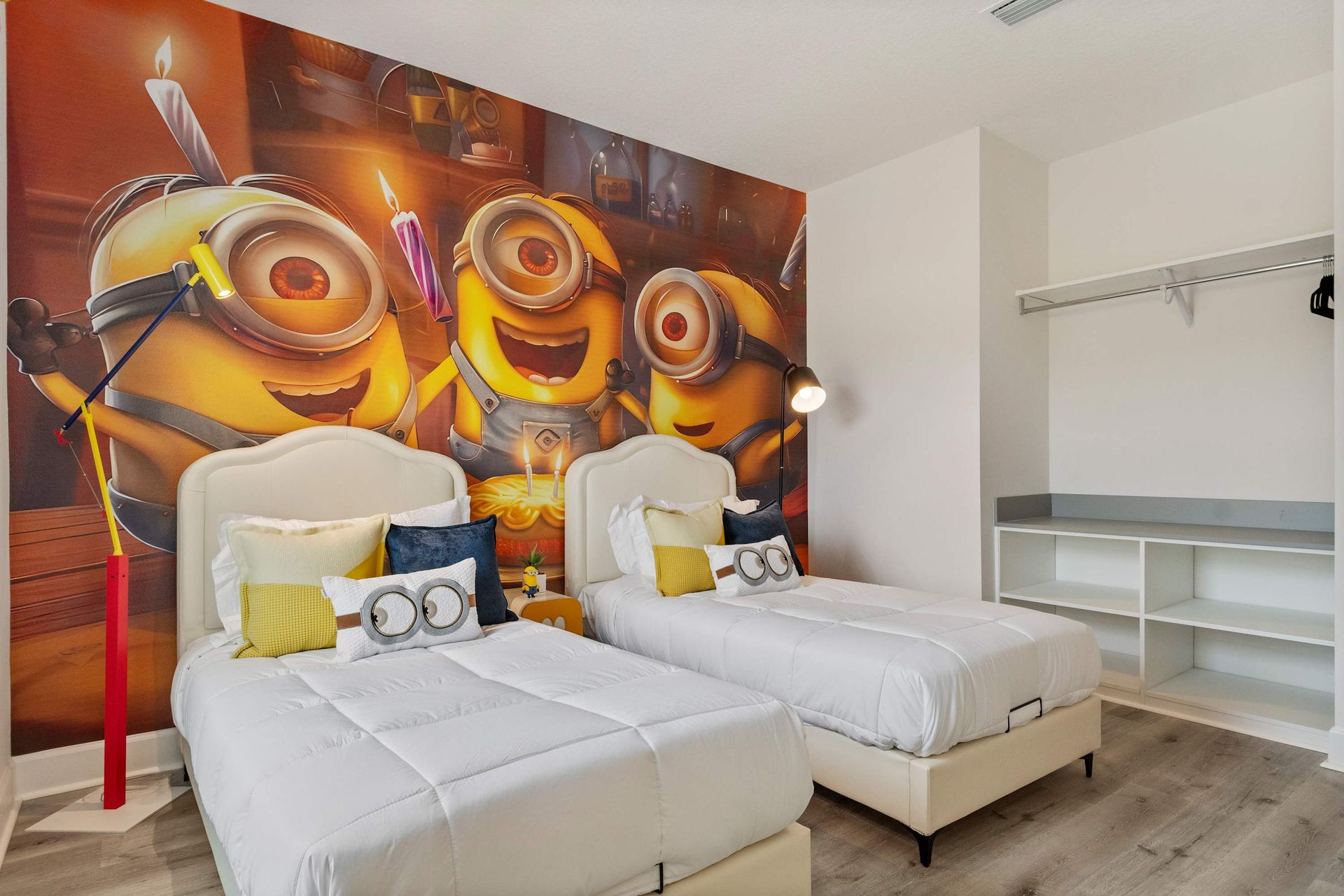 Bright and fun Minion-themed bedroom with twin beds and playful movie mural
