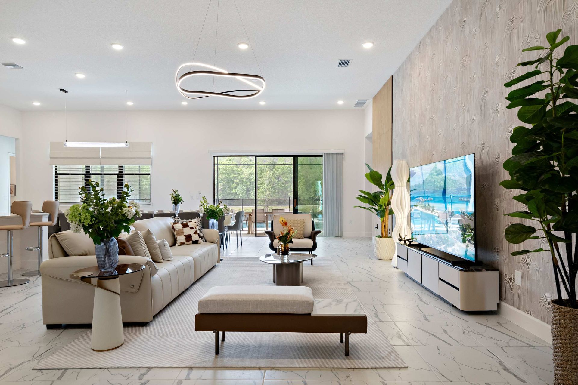 Spacious modern living area with sleek design, large TV, and natural light
