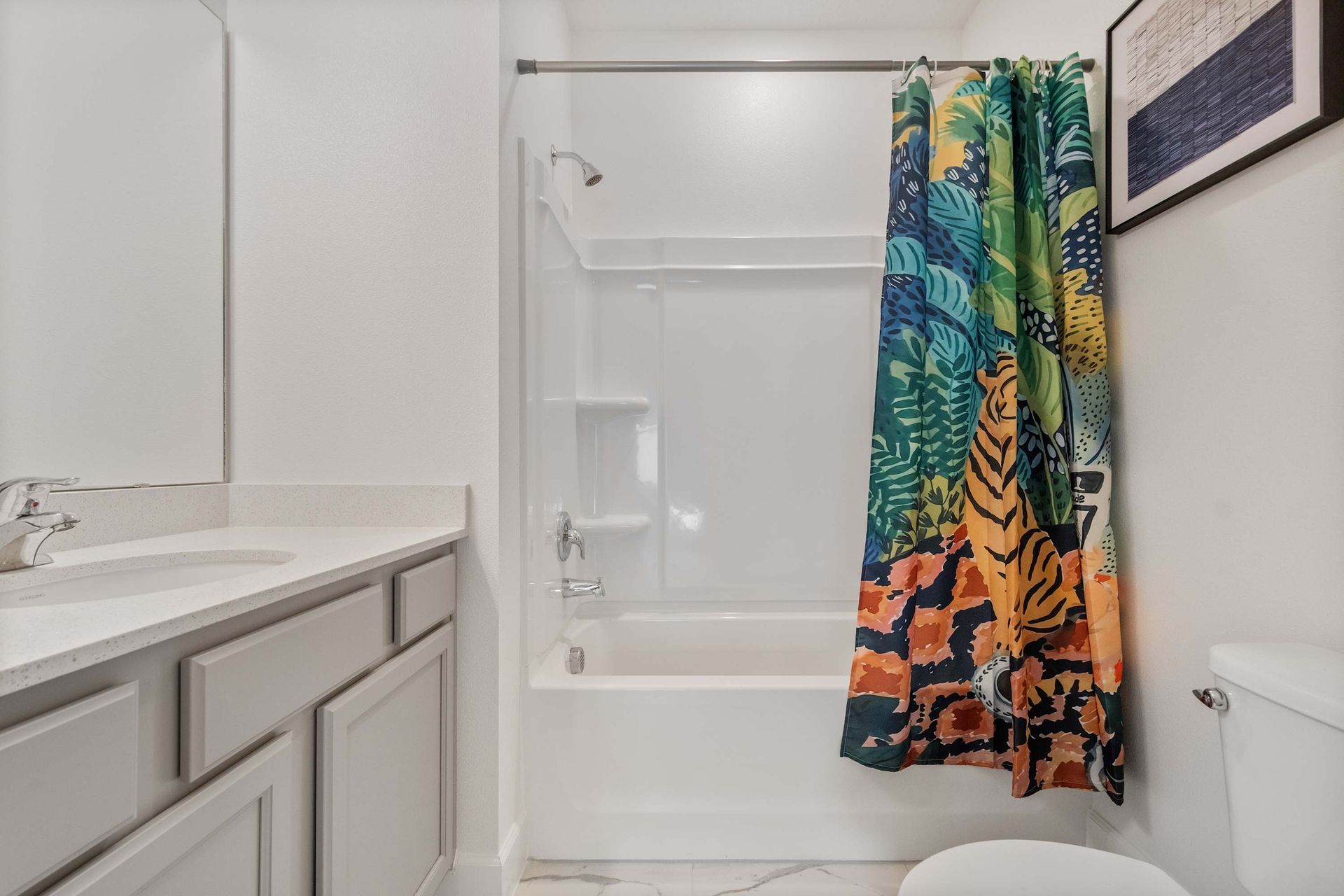 Vibrant bathroom with colorful jungle-themed shower curtain and sleek modern vanity

