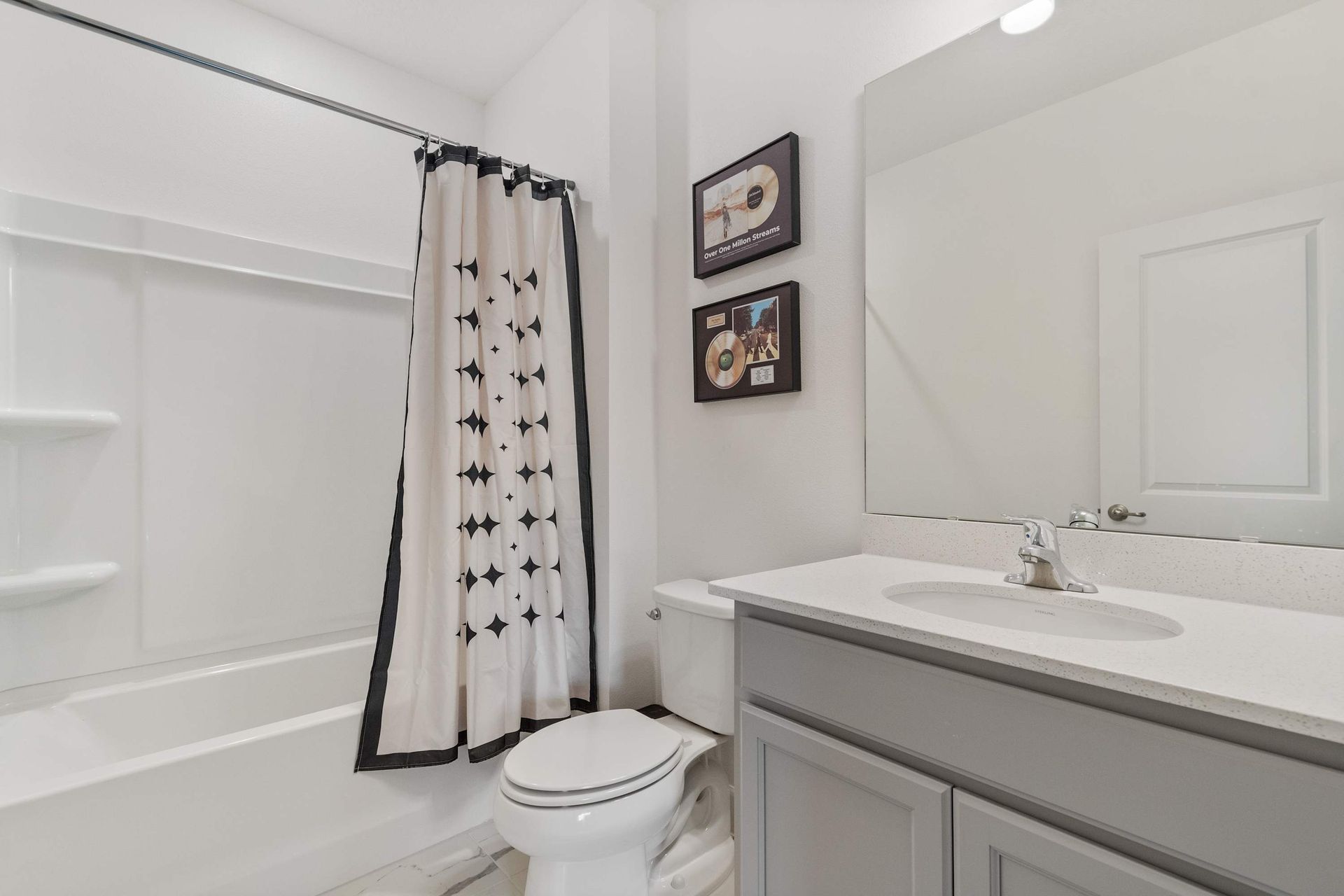 Crisp and modern bathroom with patterned shower curtain, sleek vanity, and clean lines
