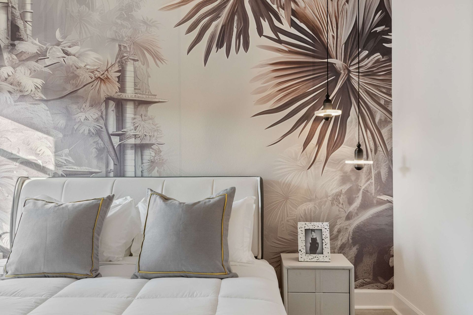 Tropical-inspired bedroom with bold accent wall, cozy bed, and modern lighting
