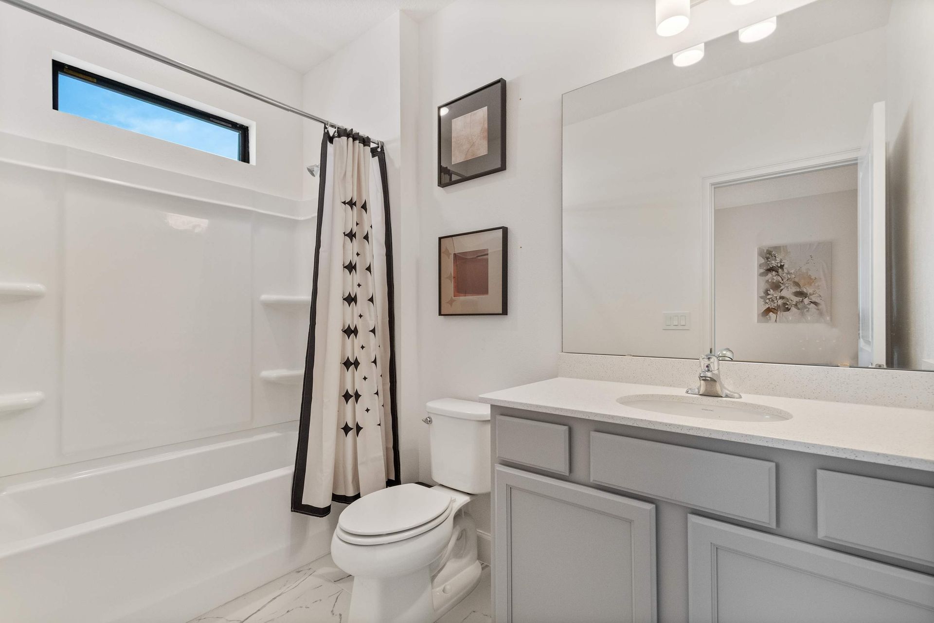 Modern bathroom with black and white accents, sleek vanity, and bright natural light
