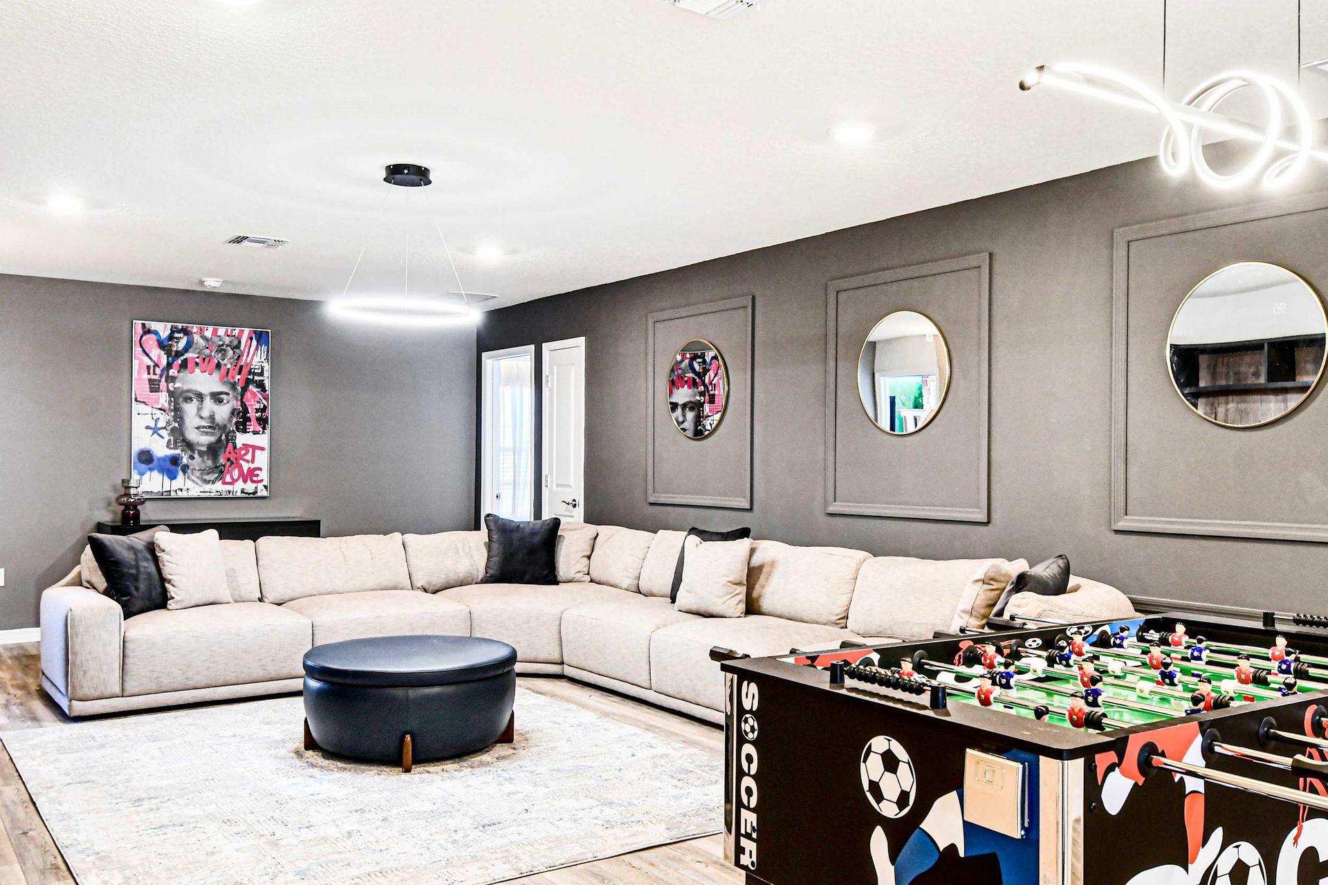 Stylish game lounge with foosball, modern art, and a spacious sectional sofa!
