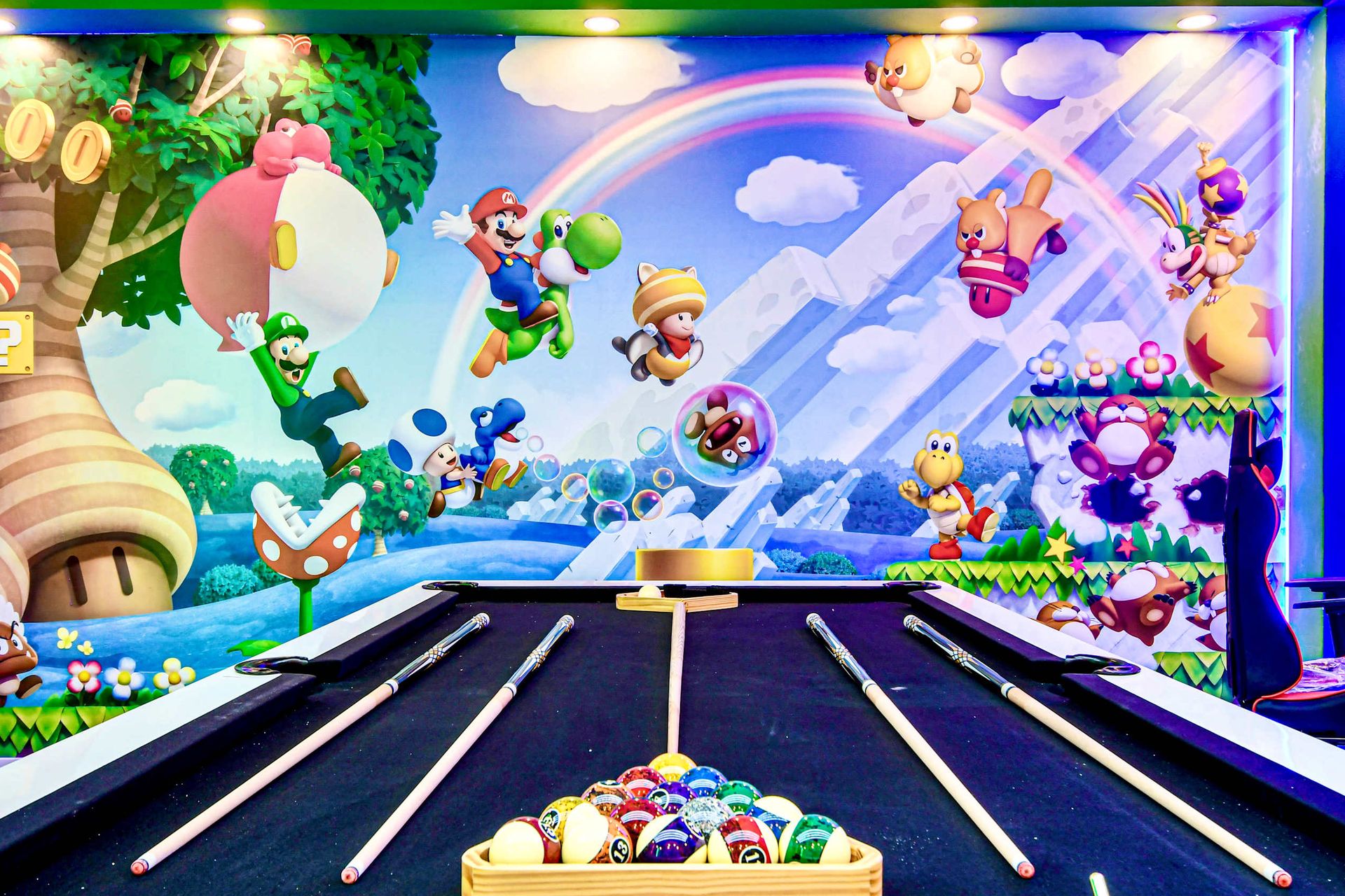 Colorful Super Mario game room with pool table, mural wall, and arcade vibes!
