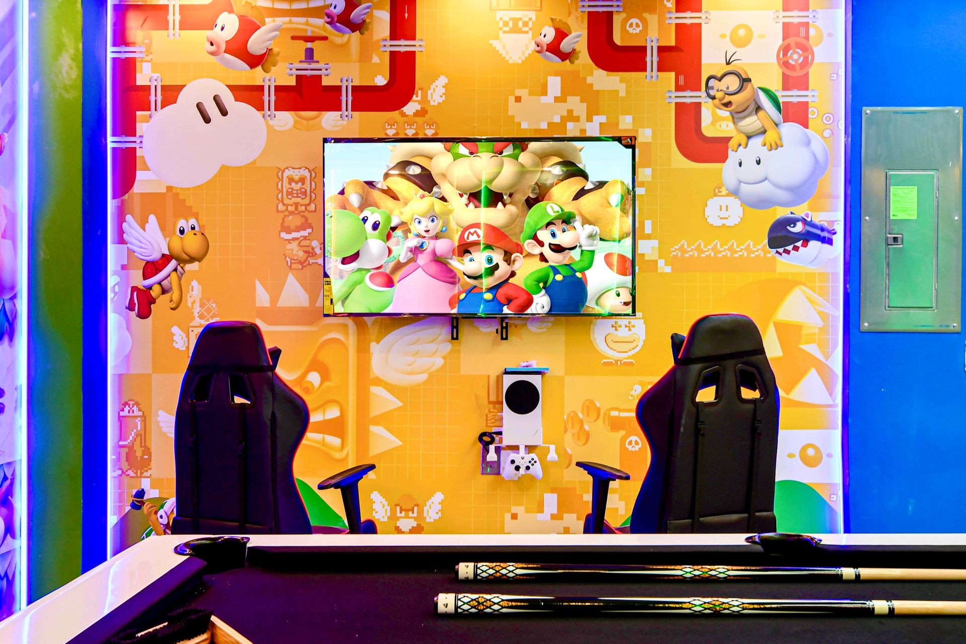 Vibrant Super Mario gaming zone with dual chairs, wall art, and pool table fun!
