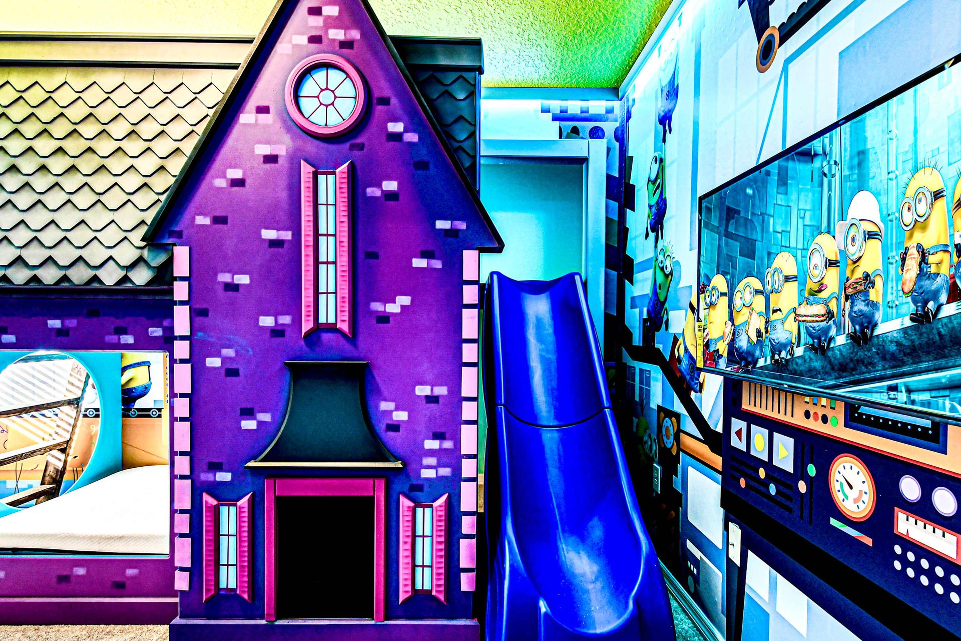 Minion-themed kids' room with playhouse bunk, slide, and fun movie setup!
