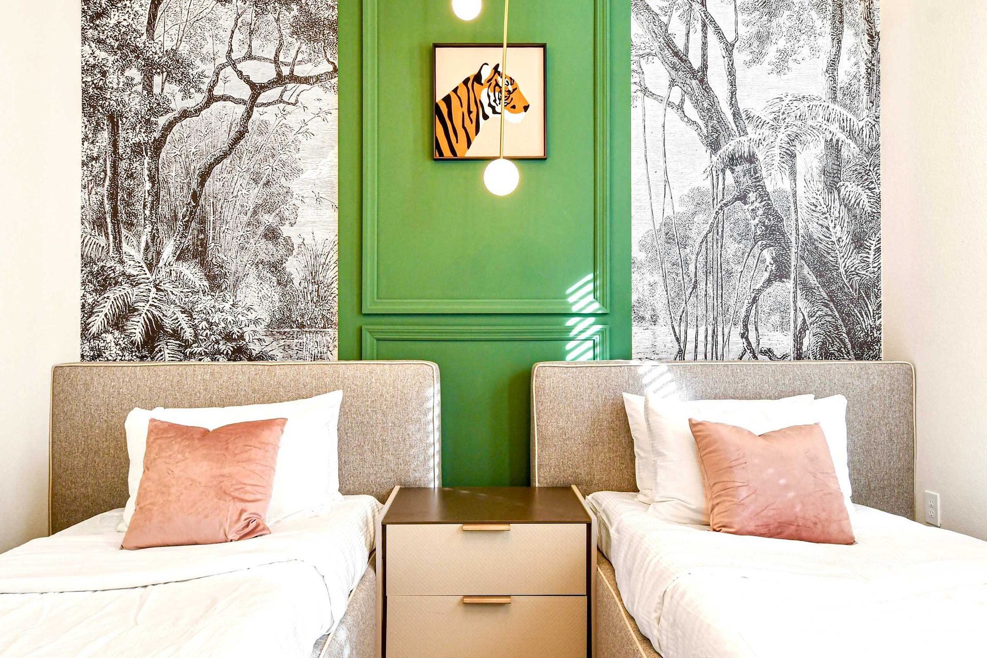 Chic twin room with jungle mural accents, modern lighting, and cozy vibes!
