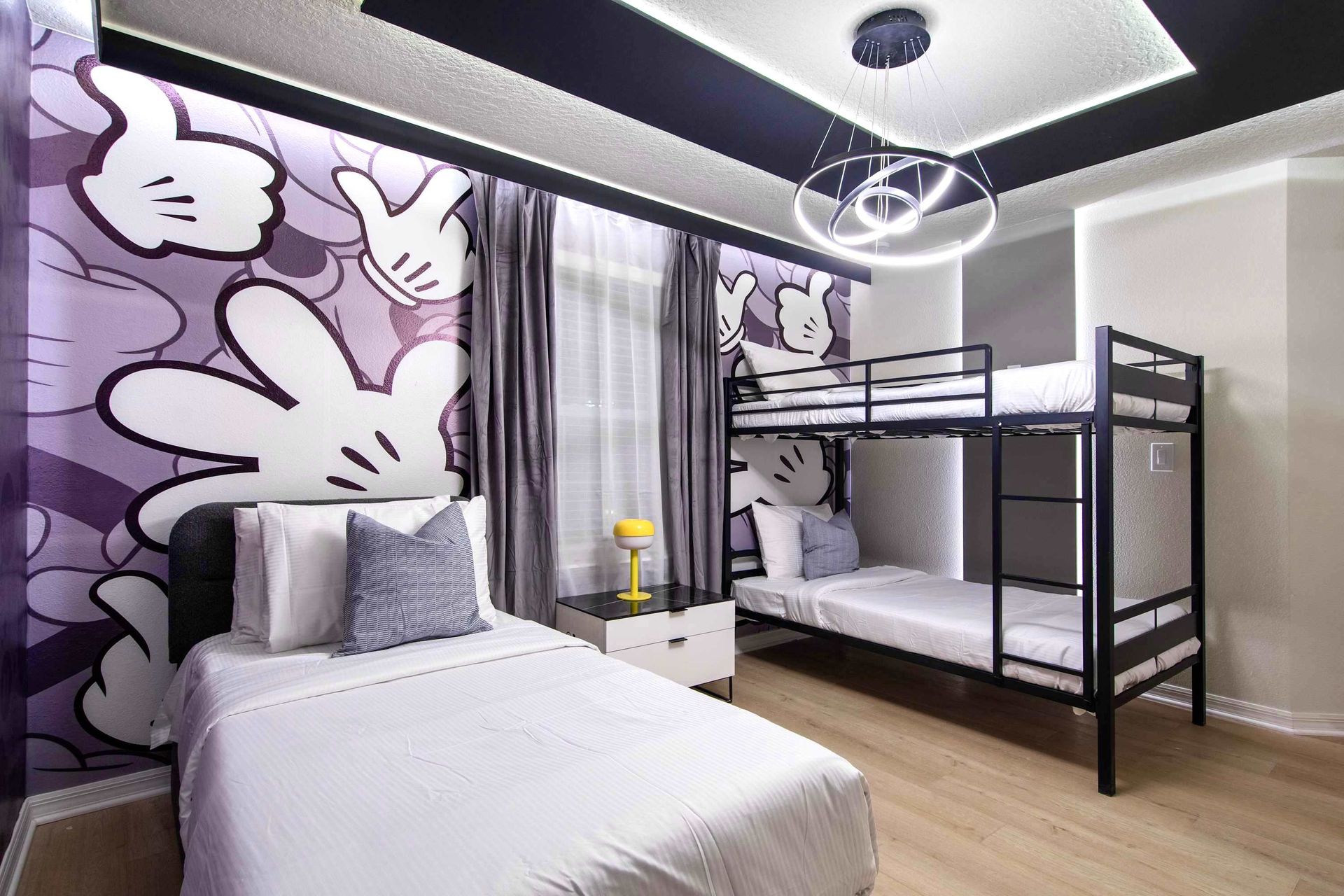 Playful cartoon-themed room with bold wall art, bunk beds, and modern lighting
