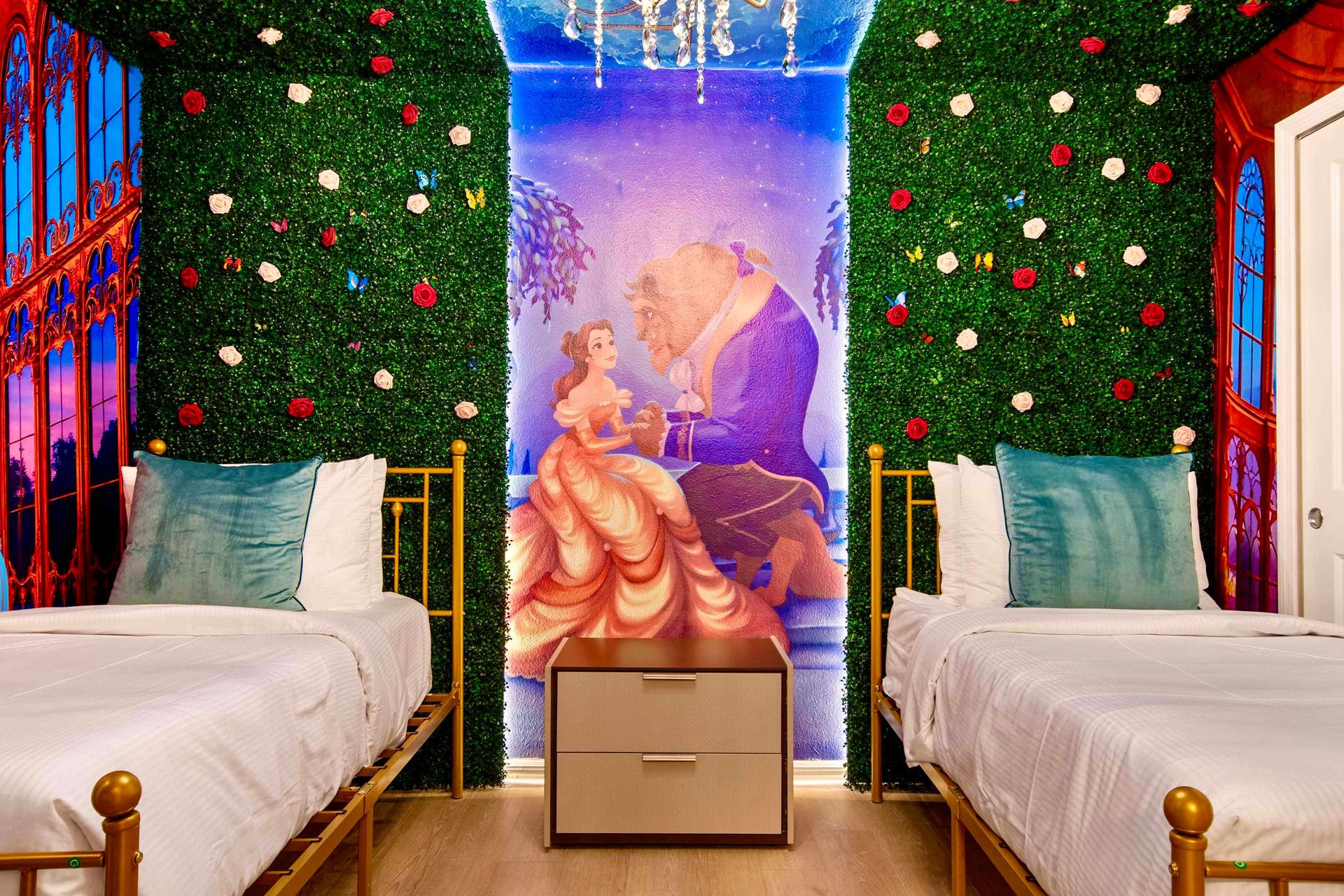 Futuristic neon bunk room with immersive lighting and sci-fi themed design
Whimsical fairy tale room with twin beds and enchanting Beauty and the Beast mural
