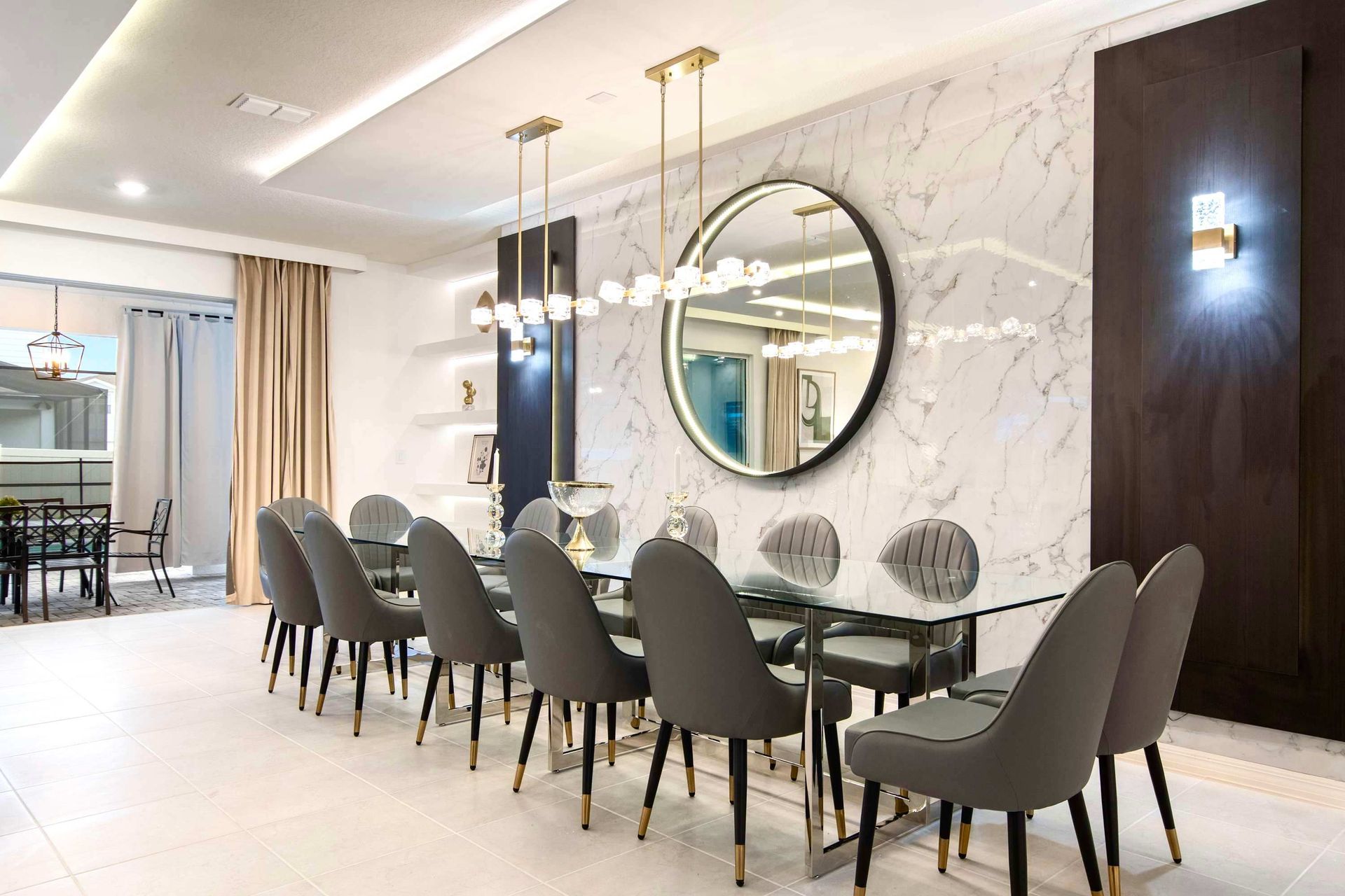 Elegant dining room with marble accent wall, modern lighting, and seating for ten
