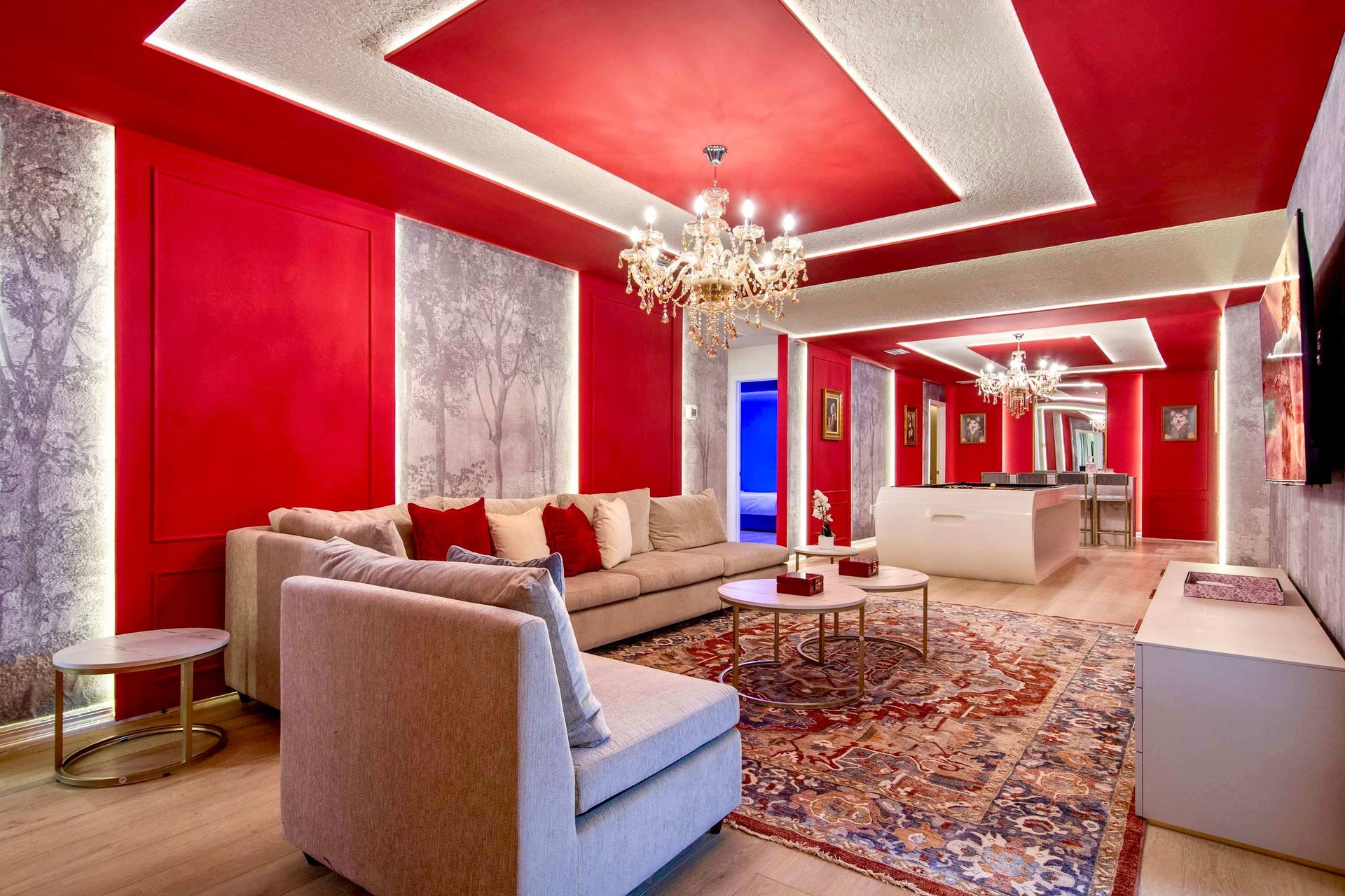 Opulent lounge with rich red accents, plush seating, chandeliers, and luxe decor
