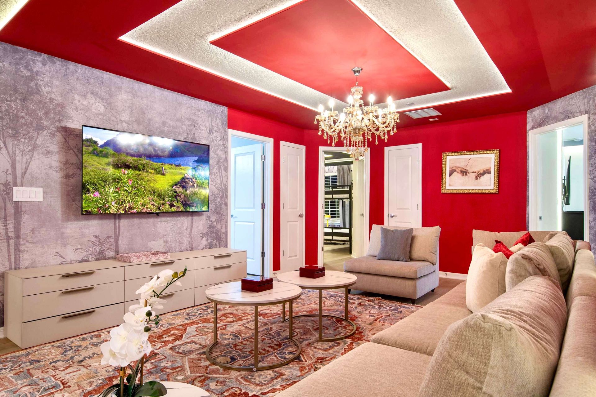 Elegant lounge with bold red accents, crystal chandelier, and cozy sectional seating
