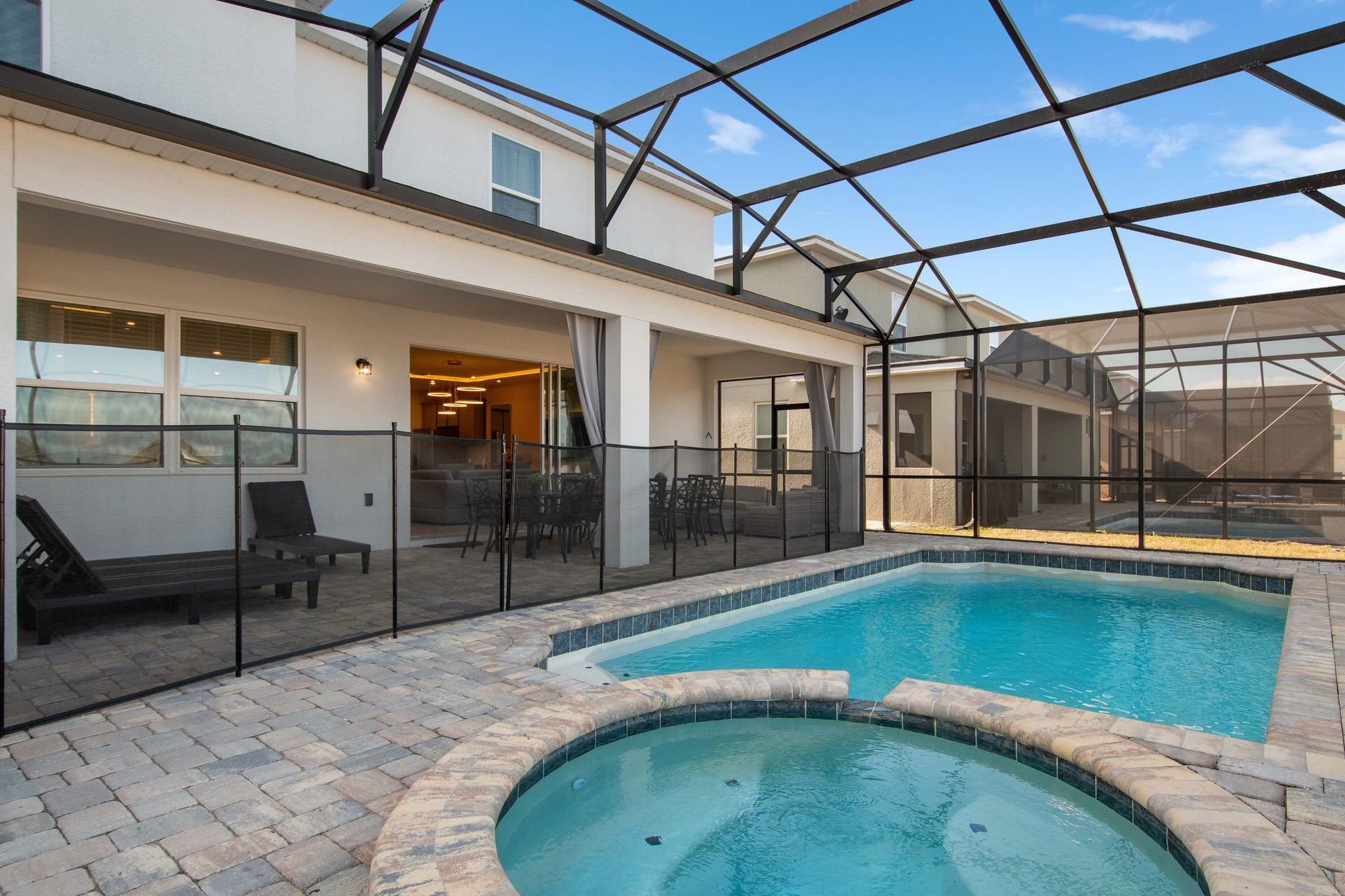 Relaxing Screened Pool and Spa with Lounge Chairs and Covered Outdoor Seating
