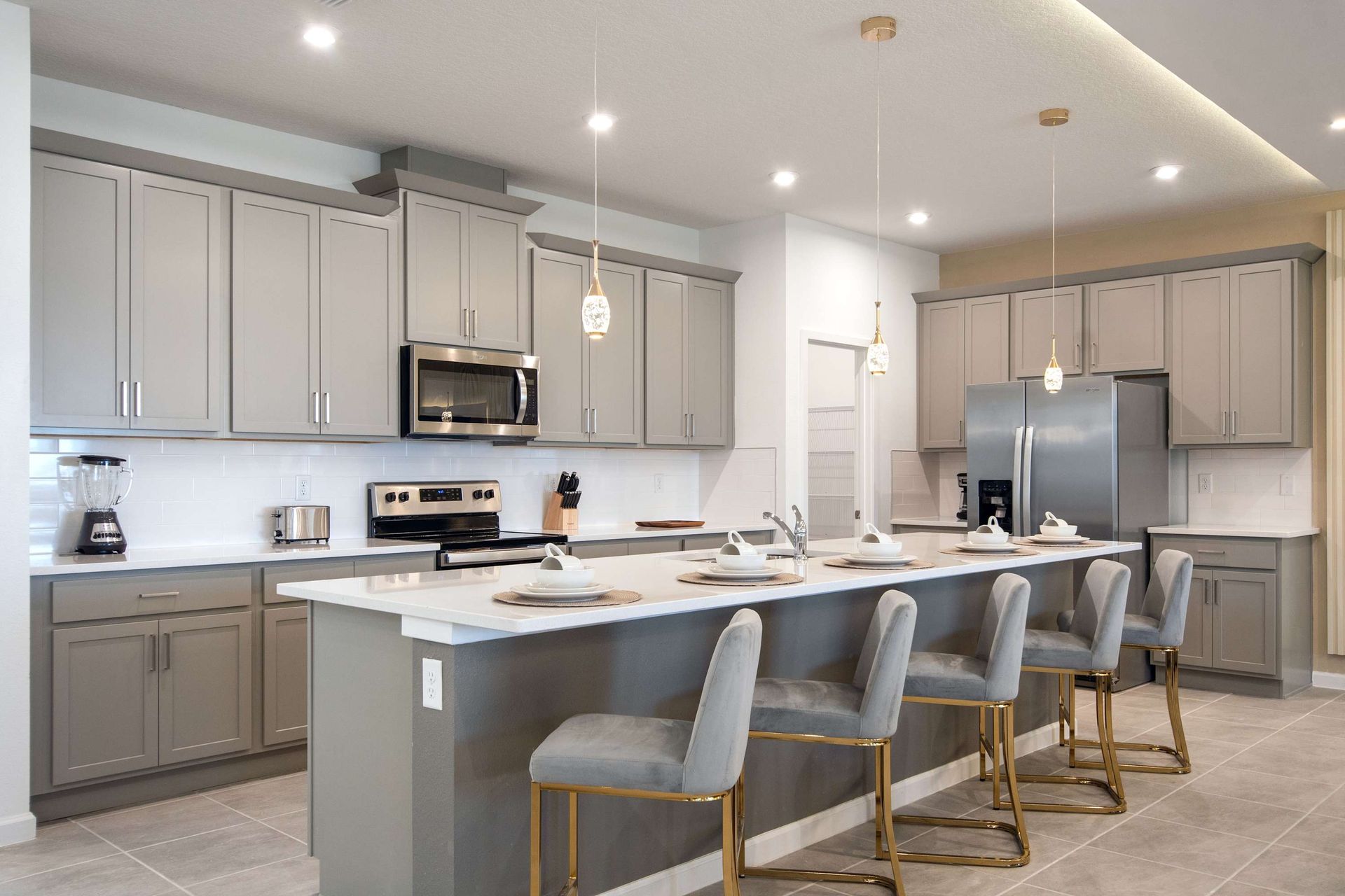 Modern Gourmet Kitchen with Large Island, Bar Seating, and Sleek Appliances
