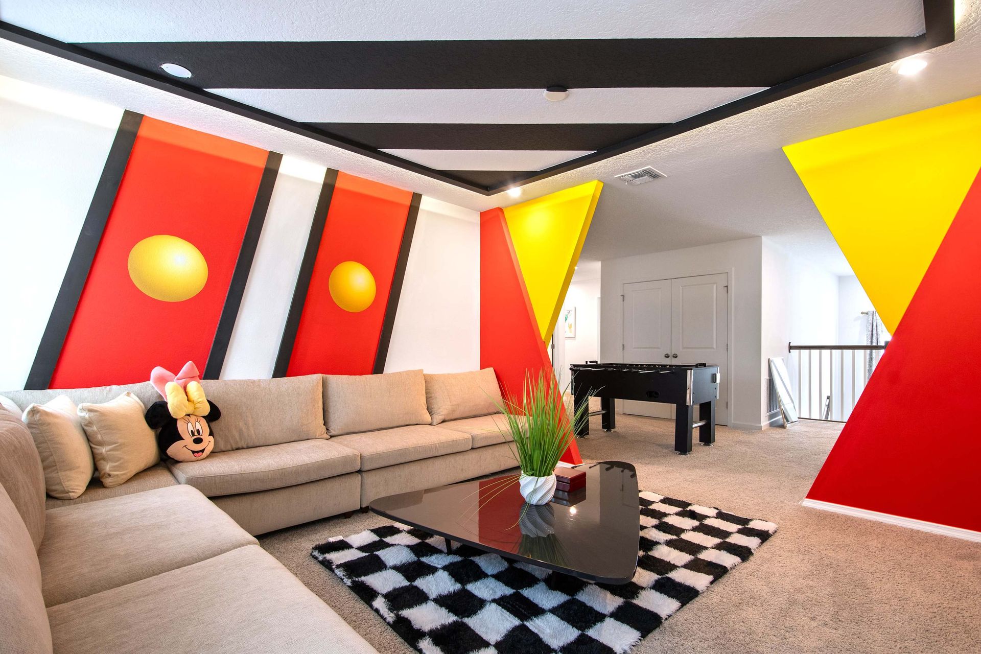 Whimsical Mickey Lounge with Bold Colors, Plush Seating & Foosball Table Fun
