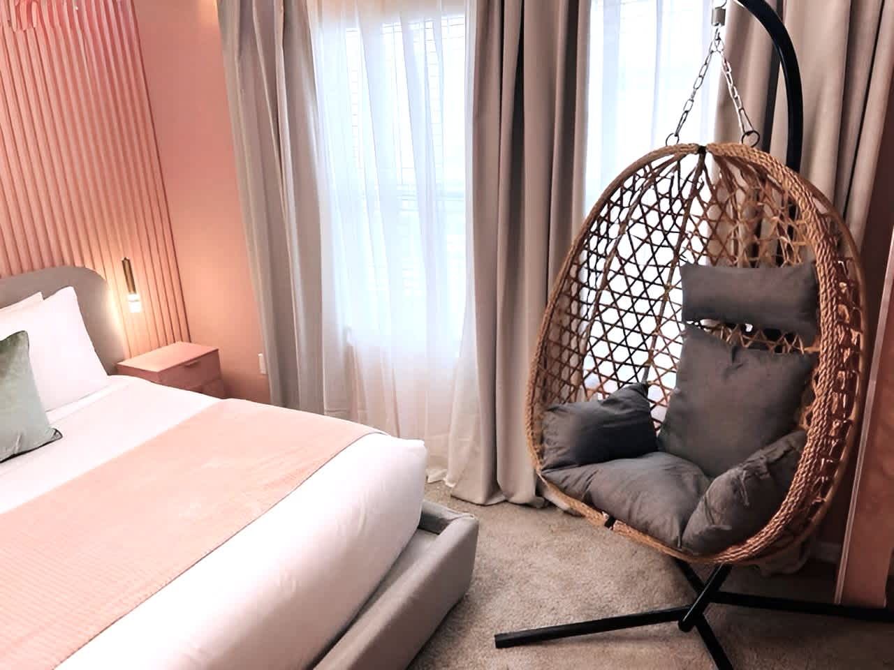 Cozy Blush Retreat with King Bed, Hanging Chair & Soft Natural Light
