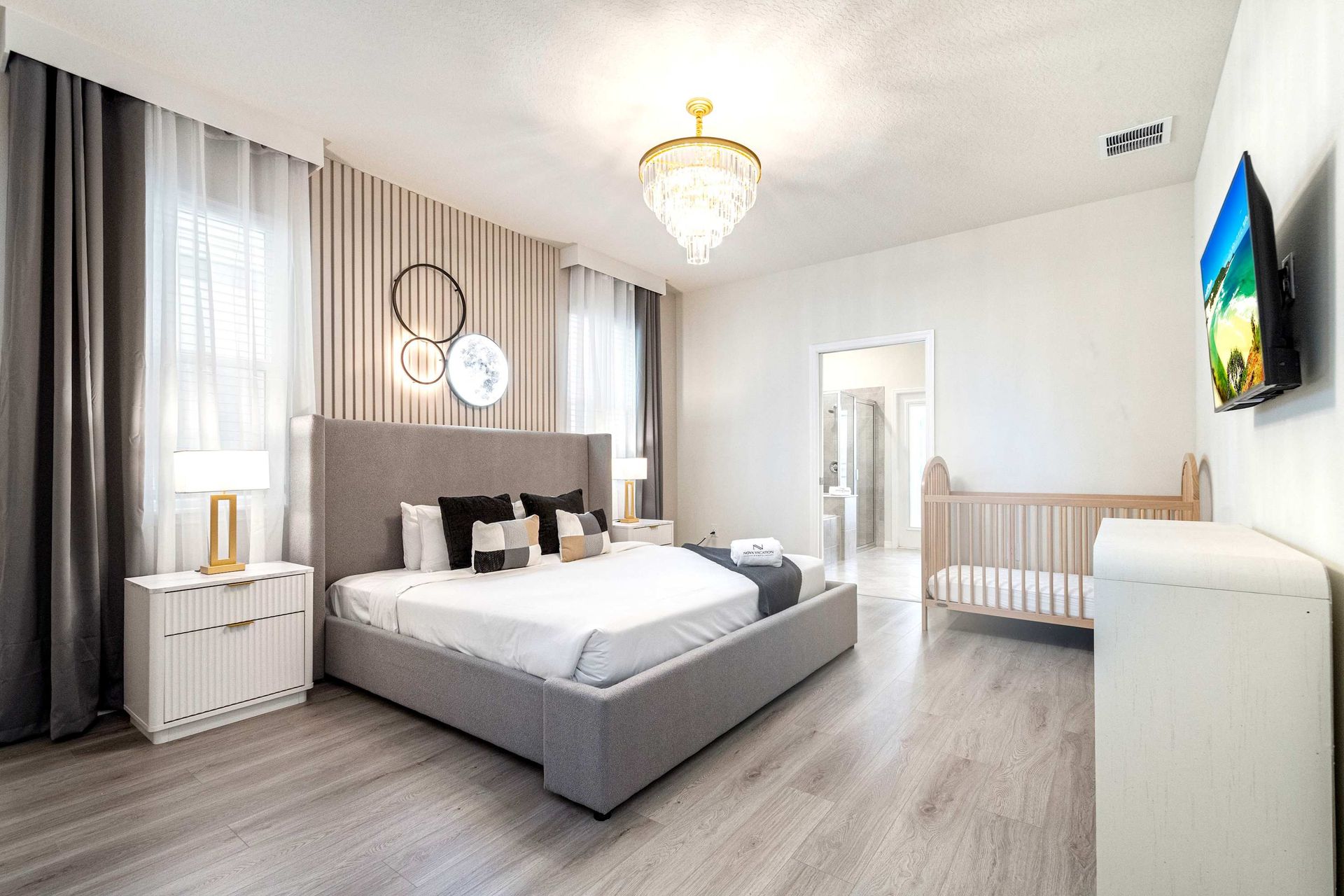 Spacious modern suite with crib, ensuite bath, and serene family-friendly style.