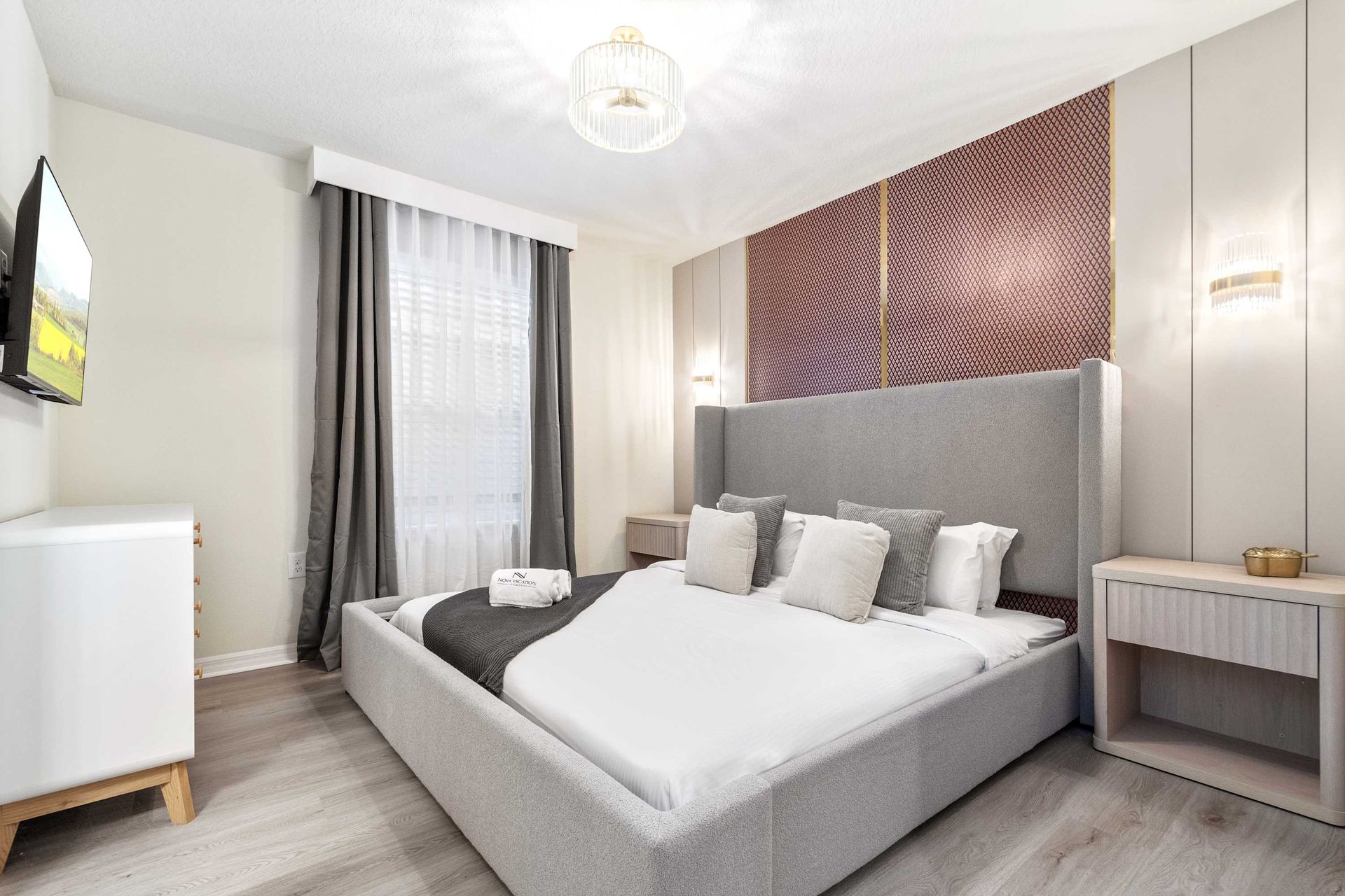 Elegant bedroom with plush king bed, TV, and luxe textures for restful nights.