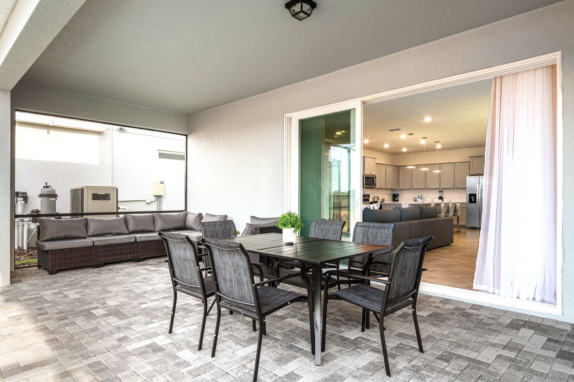 Spacious covered patio with dining, lounge seating, and seamless indoor access.