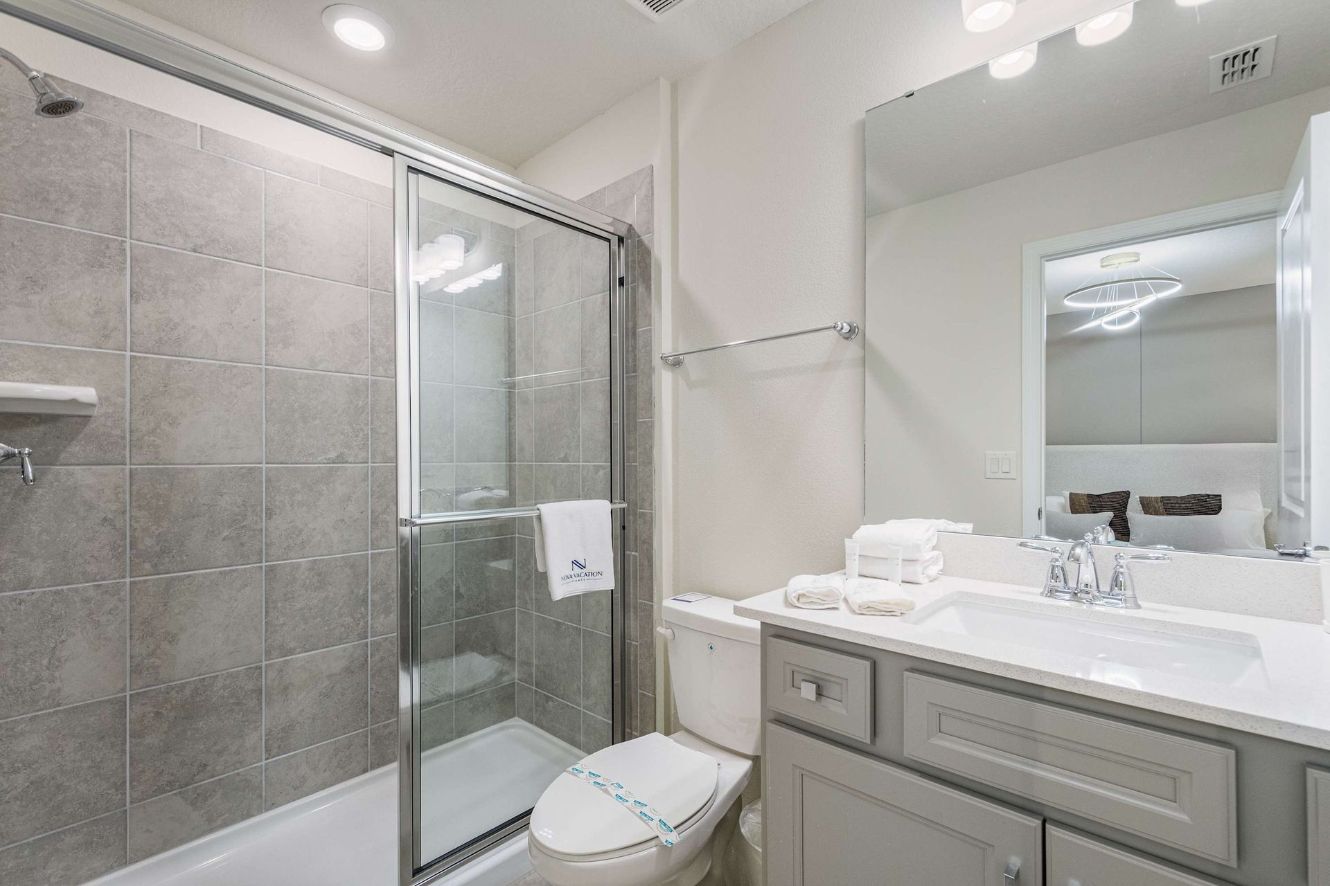 Modern bathroom with walk-in shower, sleek vanity, and fresh towels included.