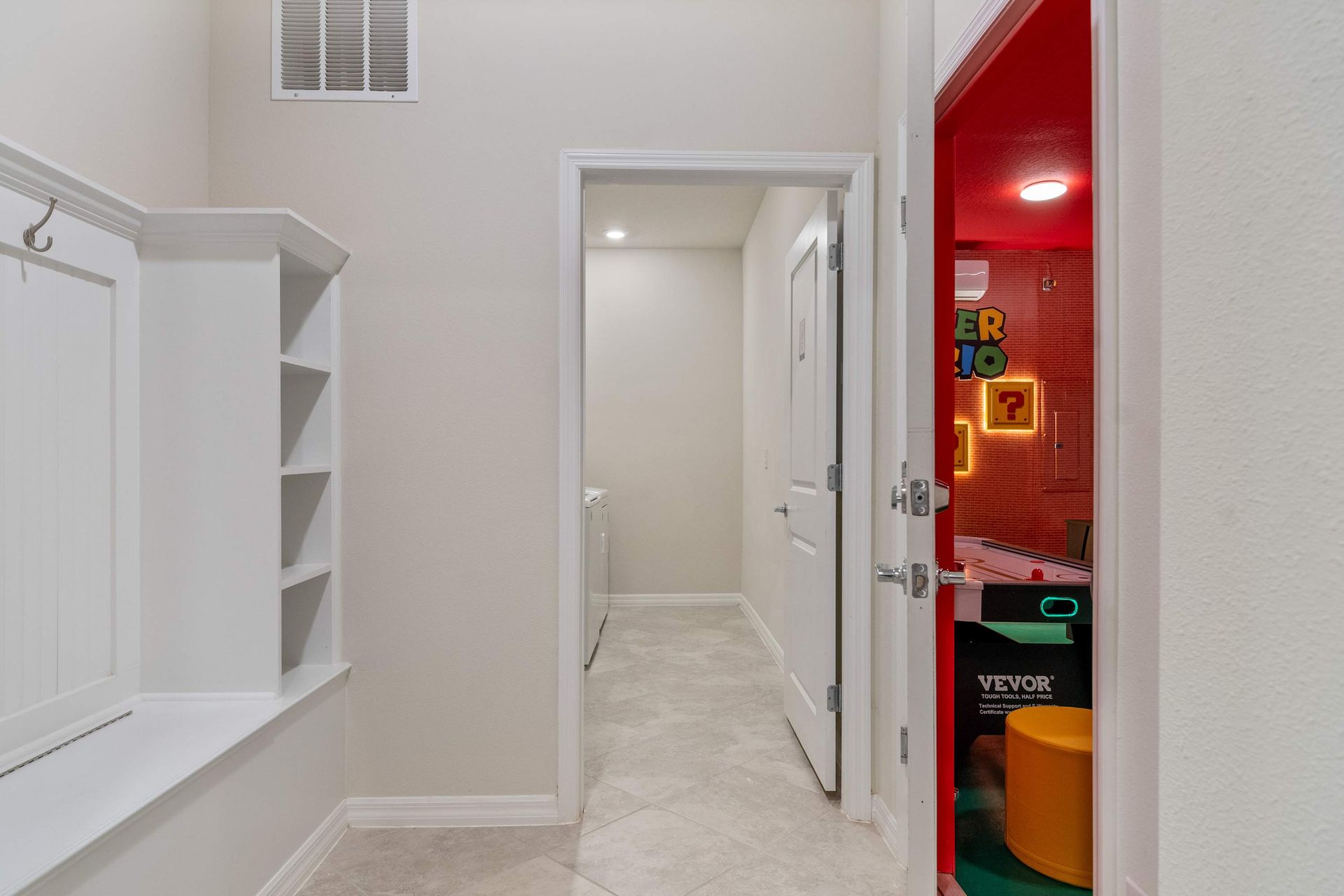 Hallway with laundry access and a peek into the vibrant Super Mario game room.