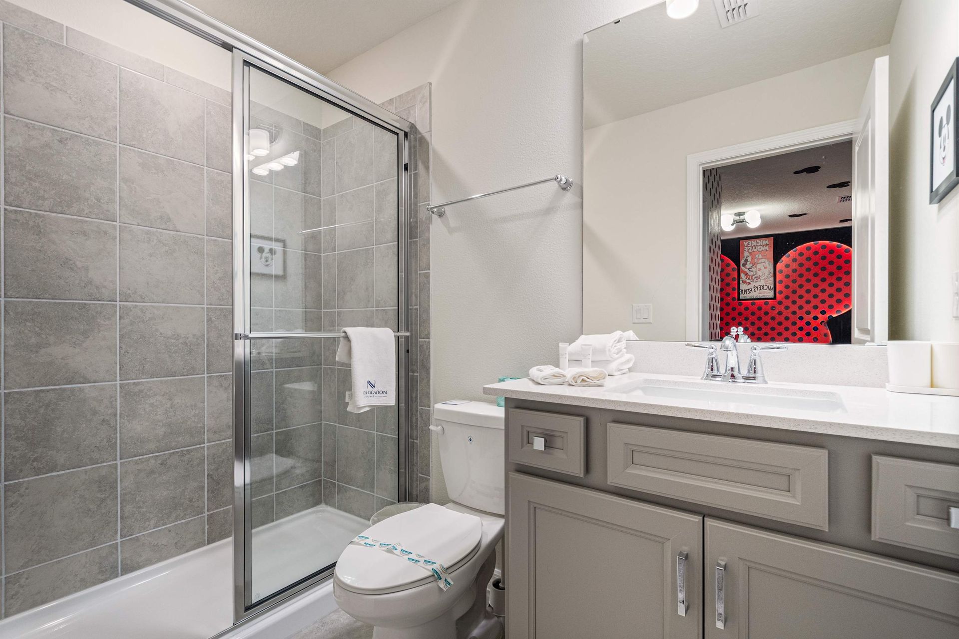 Fun and stylish bathroom with walk-in shower, connected to themed Mickey room.